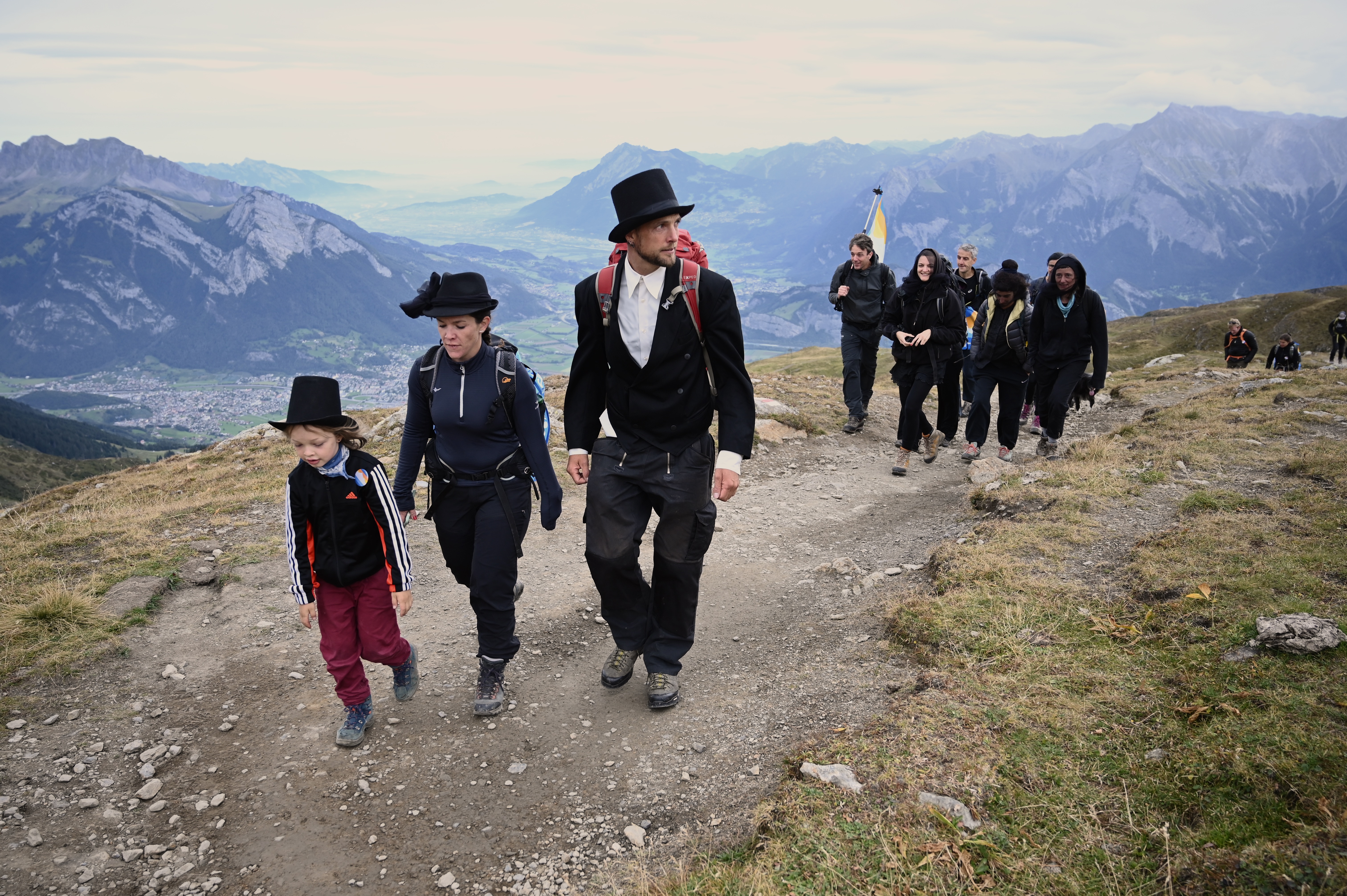 Vestidos de negro y con sombreros, la gente participa en el