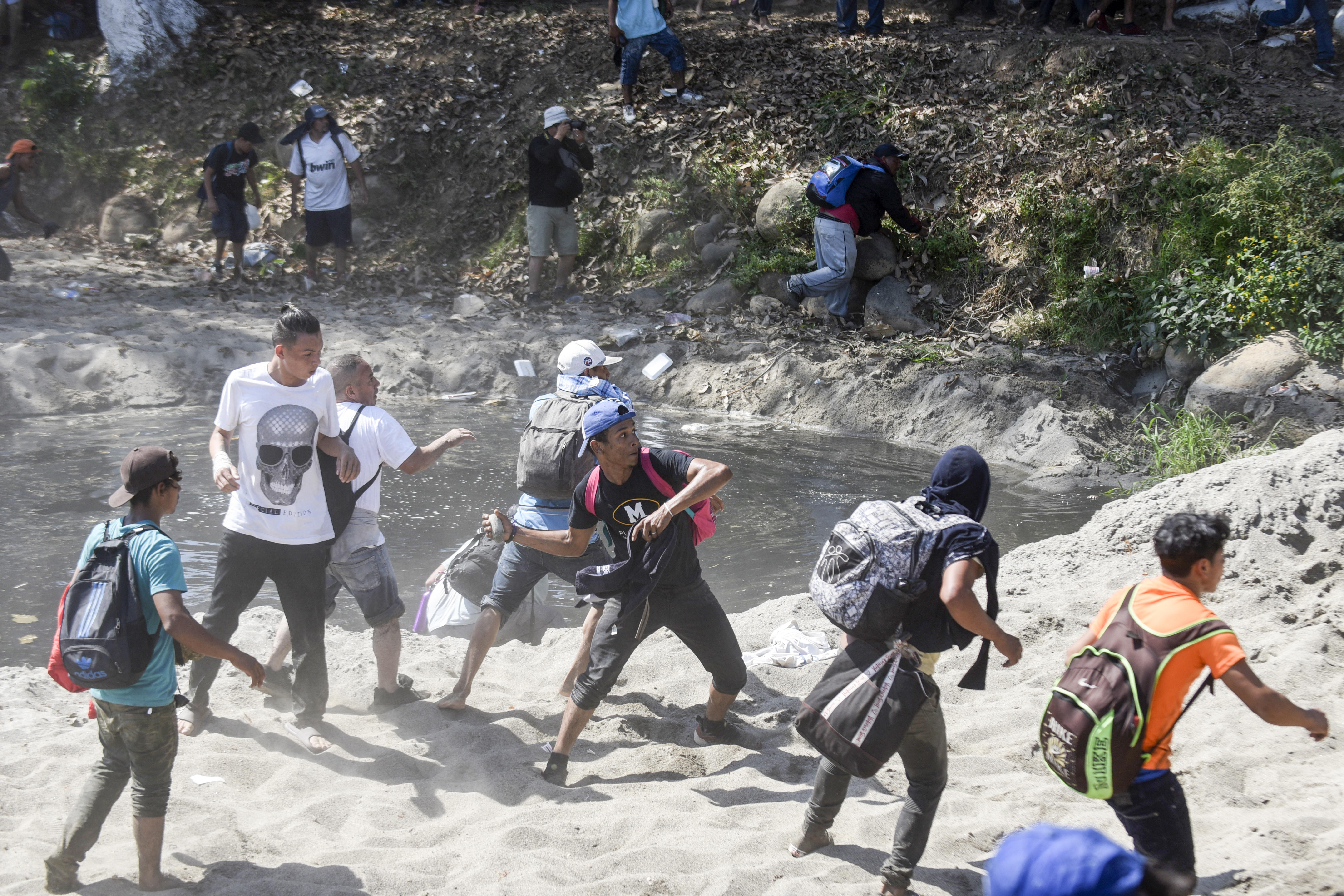 Algunos migrantes agredieron con piedras a los elementos de la Guardia Nacional por lo que estos últimos respondieron las agresiones con gas lacrimógeno (Foto: Johan Ordoñez/AFP)