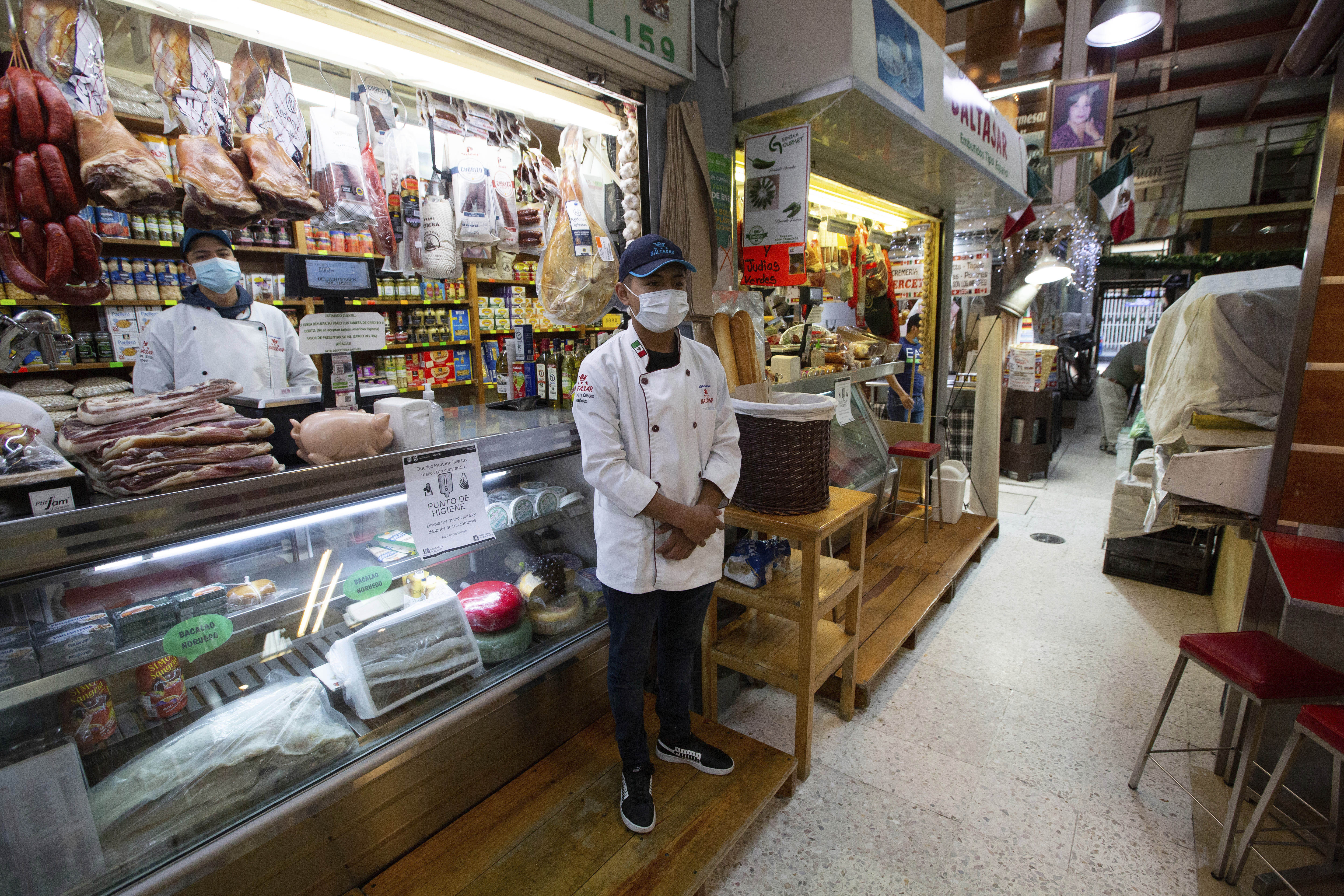 Vendedores del mercado de San Juan, en la Ciudad de México, utilizan máscaras protectoras mientras esperan a clientes
(Foto: AP Photo/Fernando Llano)