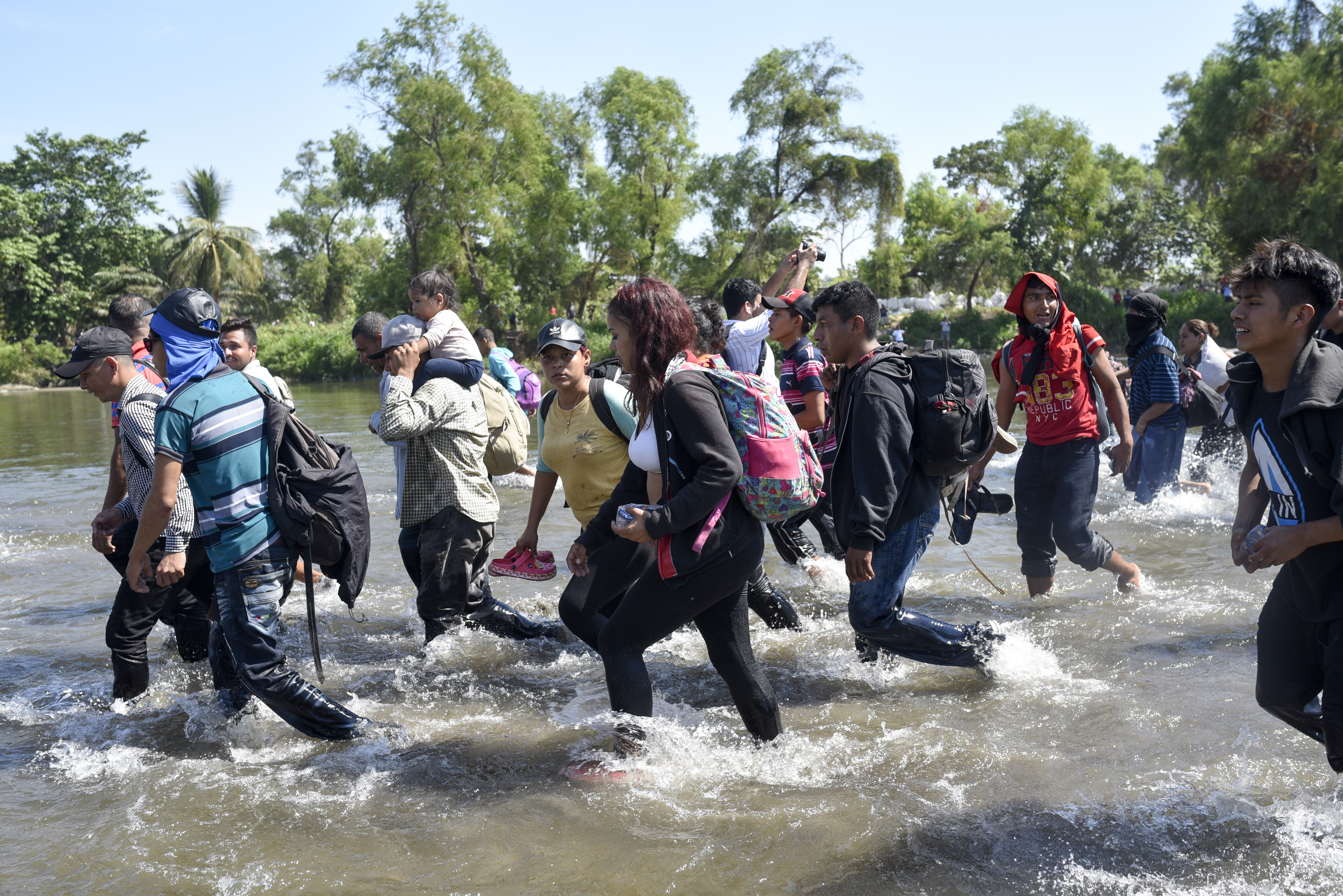 Miembros de la caravana migrante cruzando el río Suchiate a pie (Foto: Johan Ordoñez/AFP)