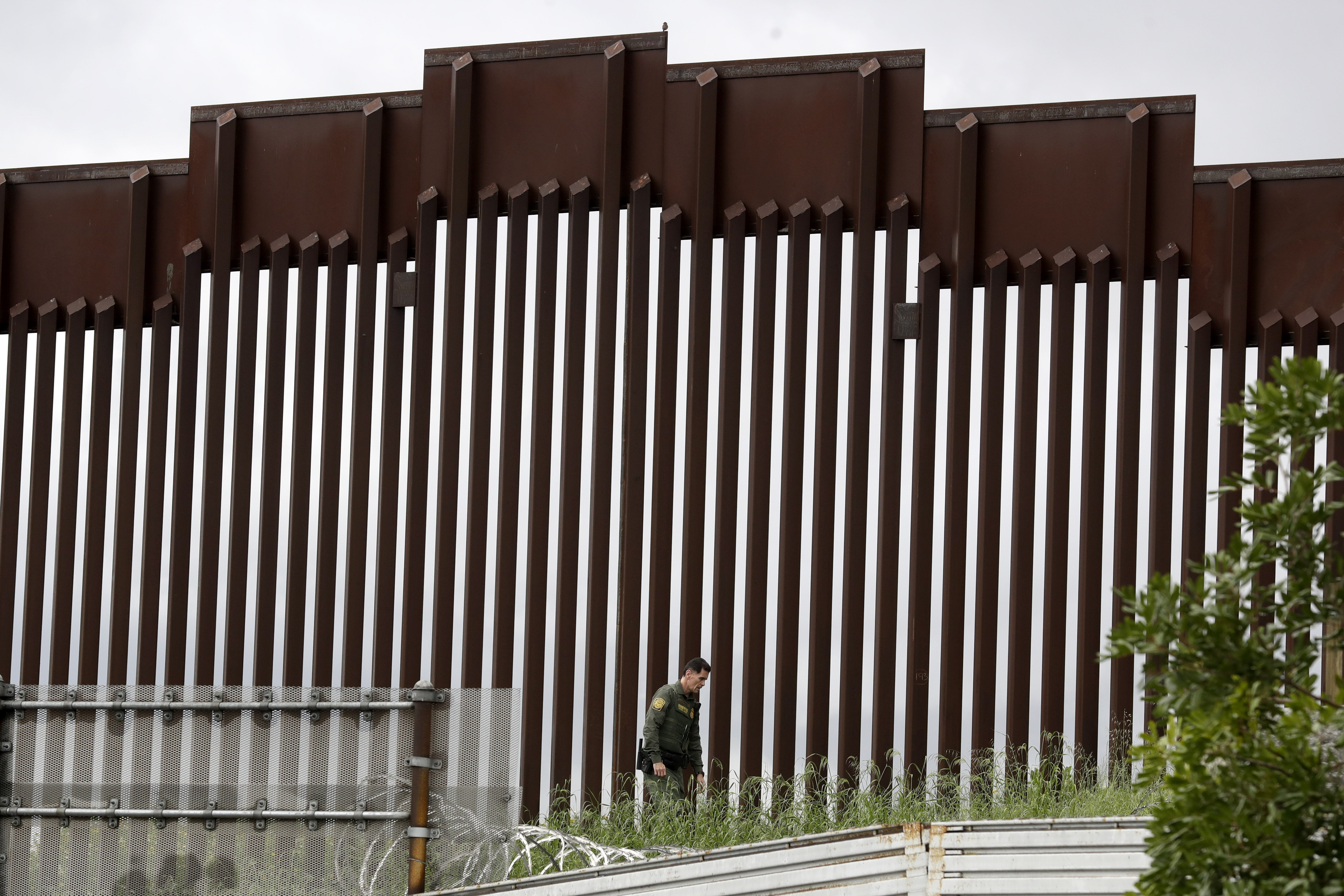 Un agente de la patrulla fronteriza camina a lo largo de un muro fronterizo que separa a Tijuana, México, de San Diego, el miércoles 18 de marzo de 2020 en San Diego.
