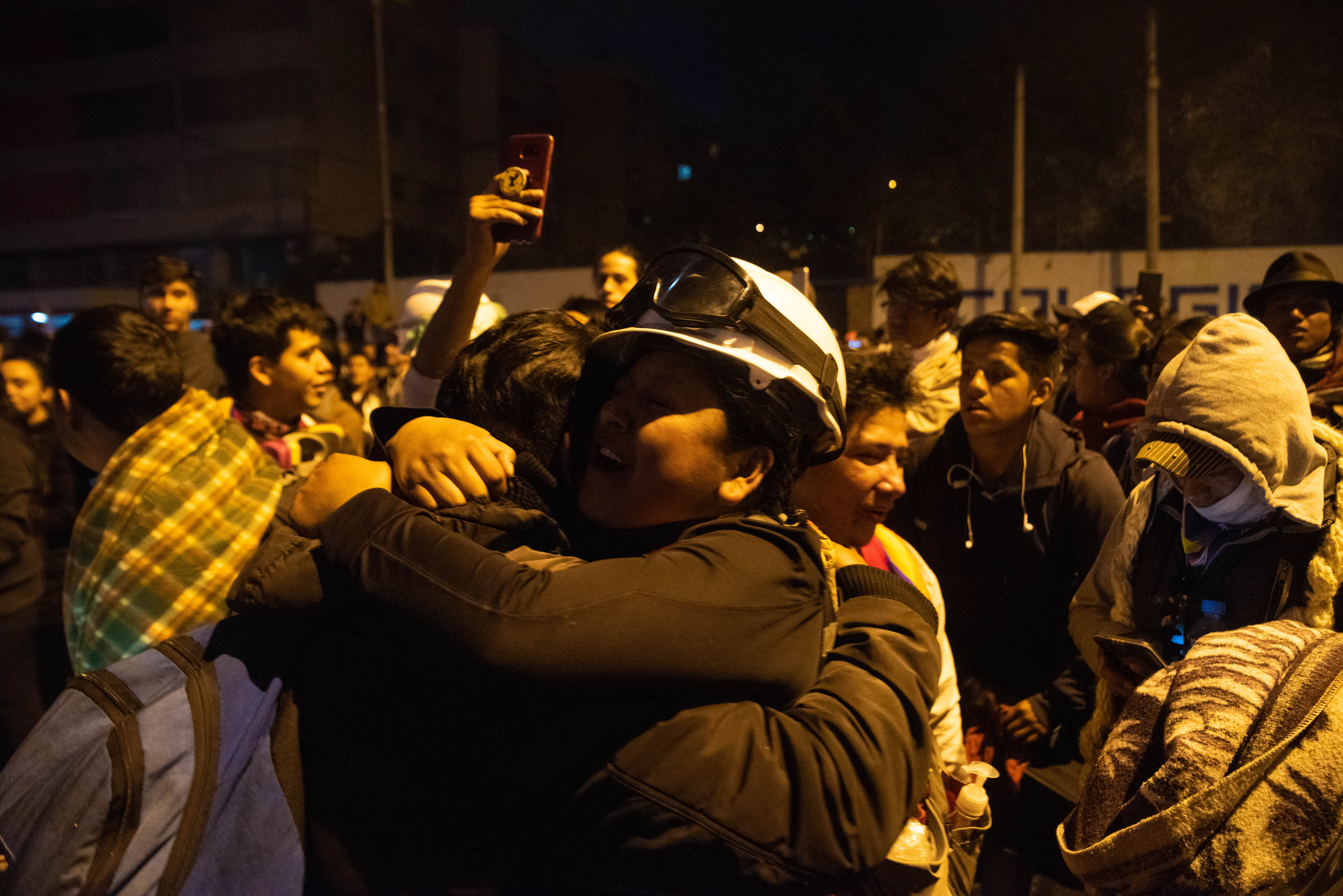 Un manifestante con casco y protección ocular se abraza con su compañeros en medio de los festejos por la derogación del Decreto 883 que eliminaba los subsidios a los combustibles.