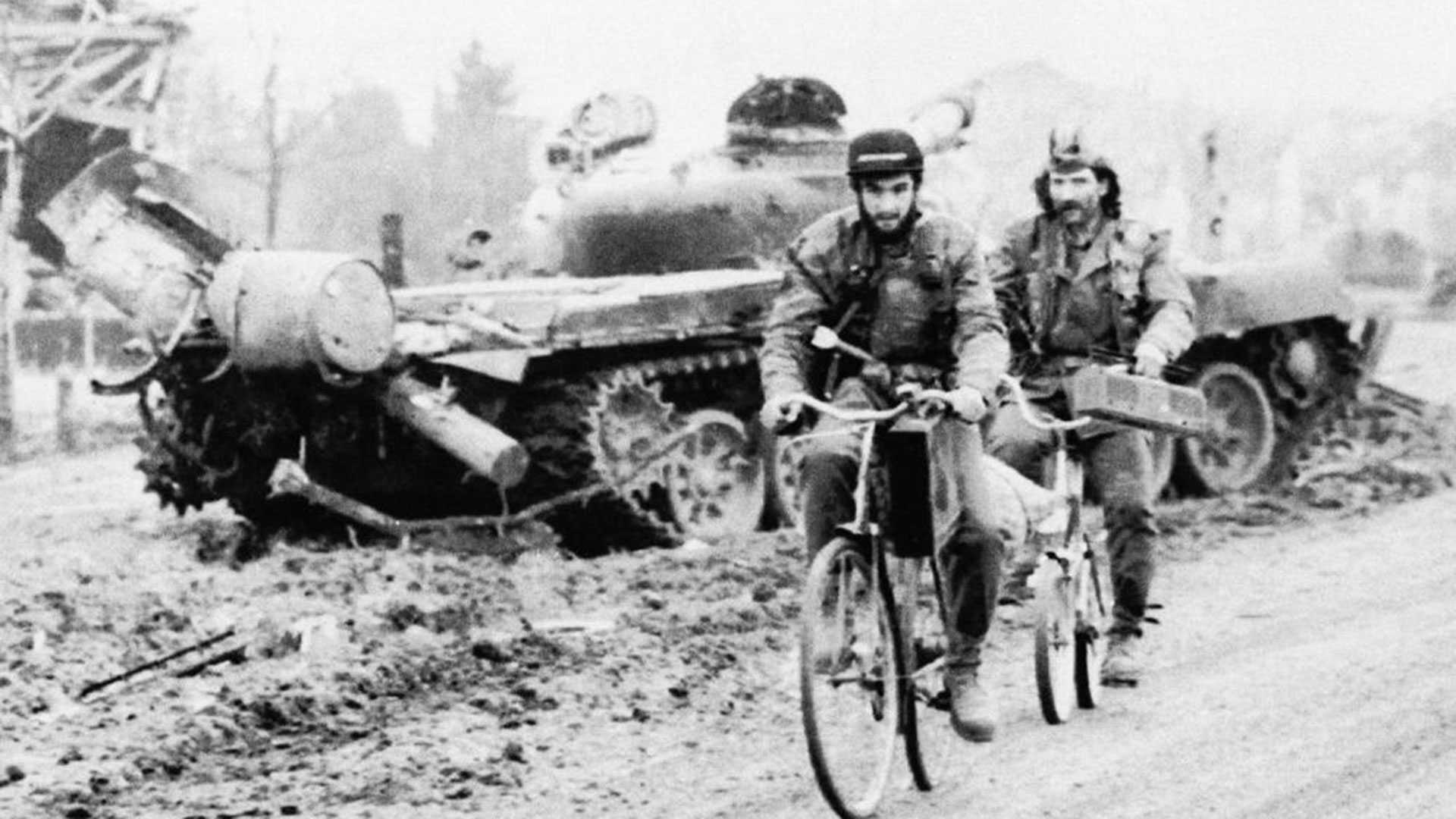 24 de noviembre de 1991. Dos voluntarios serbios pasan al lado de un tanque destruido en Vukovar, al este de Croacia. La guerra en Croacia entre el 91 y el 95 dejó cerca de 10 mil muertos y millones de desplazados. (AP Photo/Spiros Mantzarlis, File)