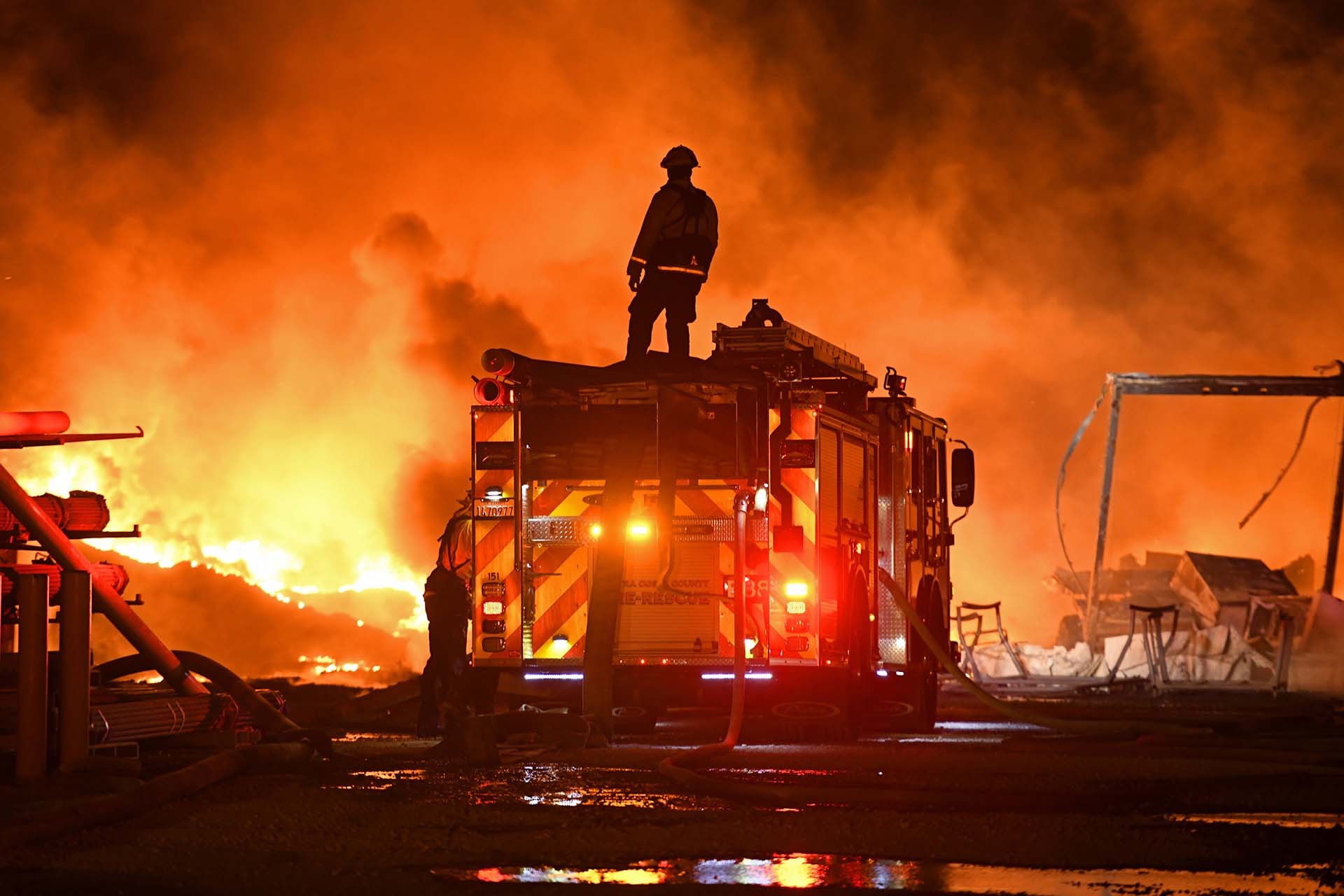 Un bombero se detiene para mirar un muro de fuego mientras lucha contra un incendio de hierba en East Cypress Road en Knightsen, California, el domingo 27 de octubre de 2019