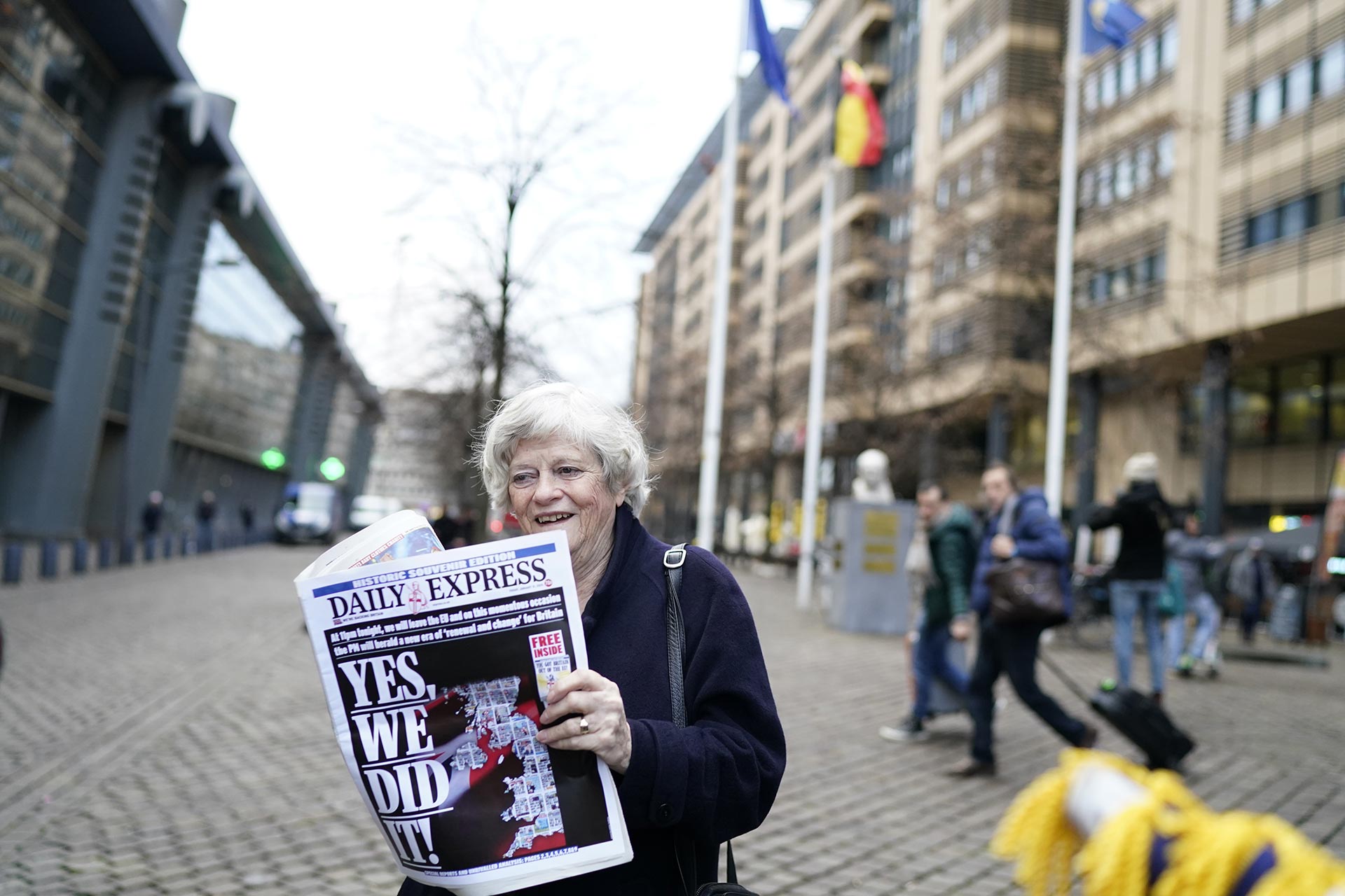 Una mujer muestra la portada de un periódico que tiene al Brexit como título principal: