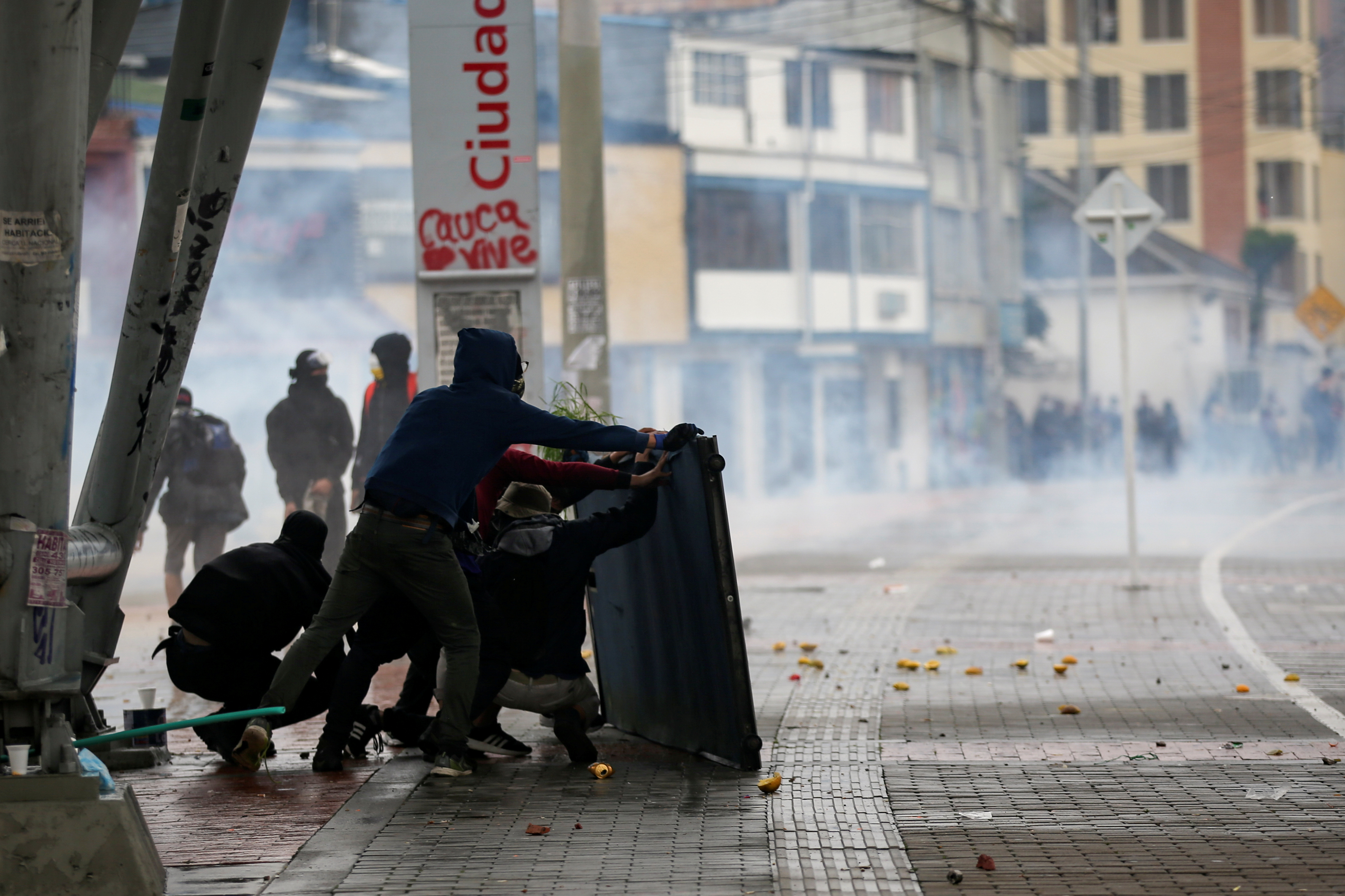 Demonstrators take cover as they clash with riot police during a protest in Bogota, Colombia, November 21, 2019. REUTERS/Luisa Gonzalez