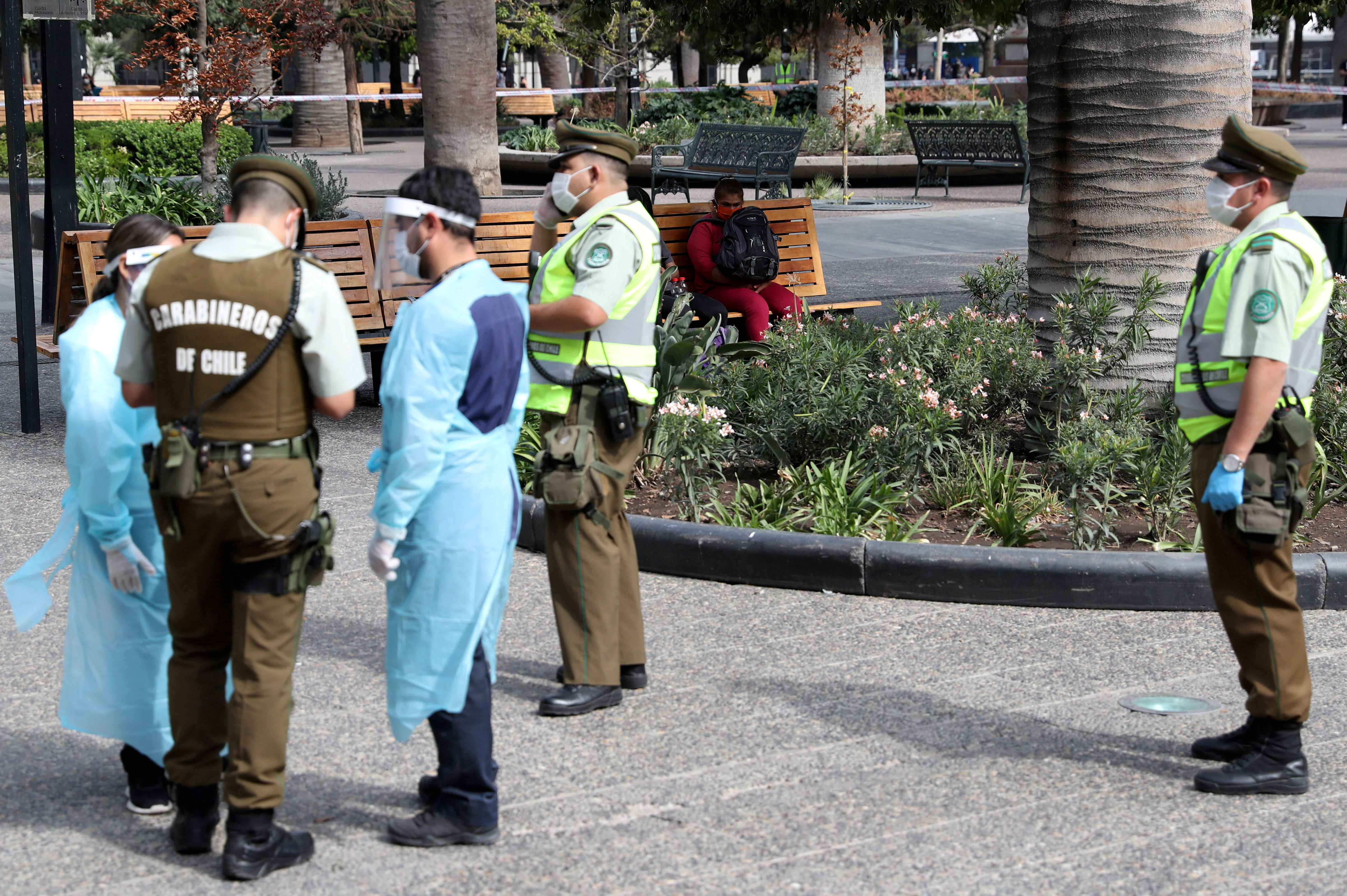 Una mujer, infectada con la enfermedad coronavirus (COVID-19) y que no respetó la cuarentena, se sienta en un banco de la Plaza de Armas después de haber sido detectada durante un control policial de rutina en Santiago de Chile el 15 de abril de 2020. REUTERS/Ivan Alvarado
