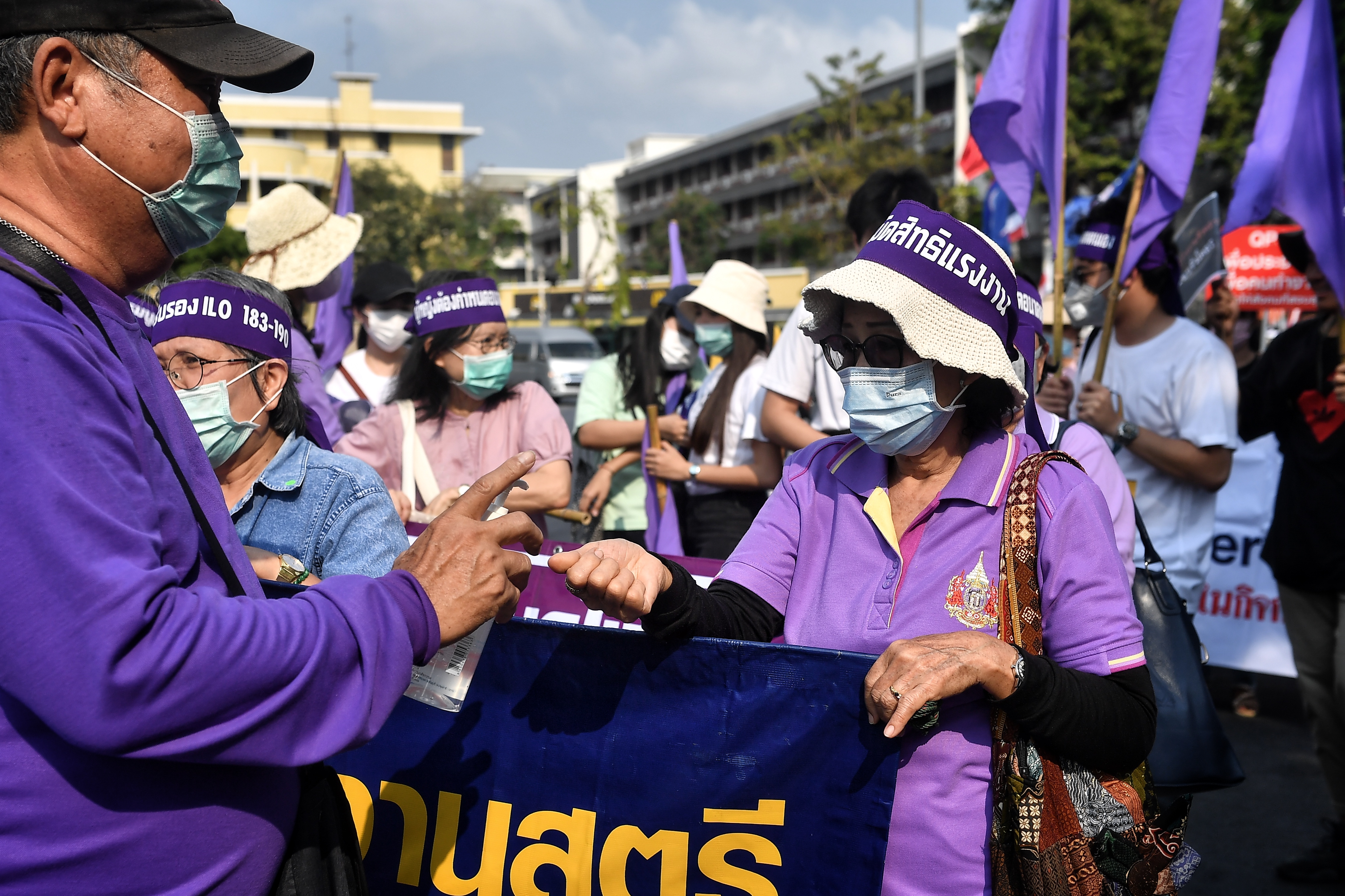 Miembros de grupos de derechos laborales tailandeses y sindicatos de empresas estatales reciben desinfectante para manos durante una marcha por los derechos laborales en el Día Internacional de la Mujer en Bangkok el 8 de marzo de 2020. (Foto de Lillian SUWANRUMPHA / AFP)