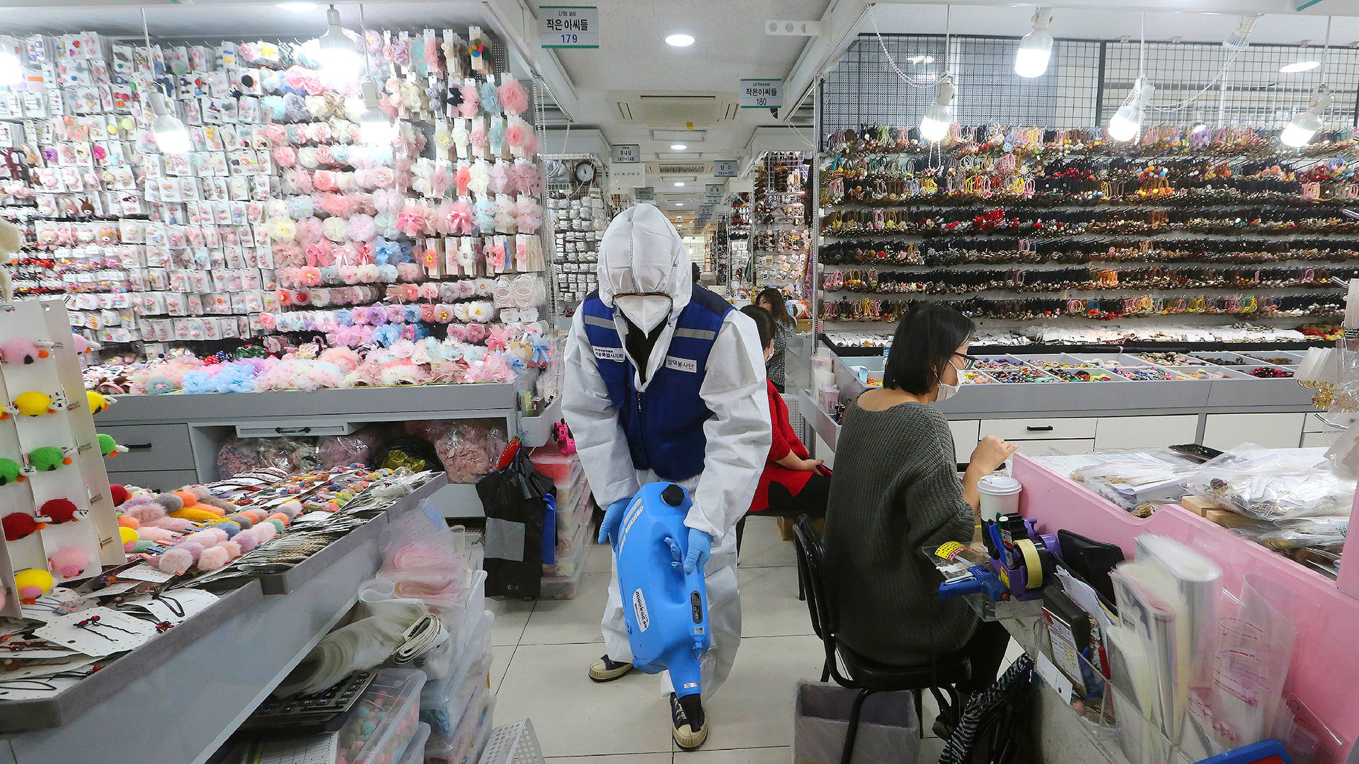 Un trabajador con engranajes protectores rocía desinfectante dentro de una tienda como medida de precaución contra un nuevo coronavirus en el mercado de Namdaemun en Seúl, Corea del Sur (AP / Ahn Young-joon)