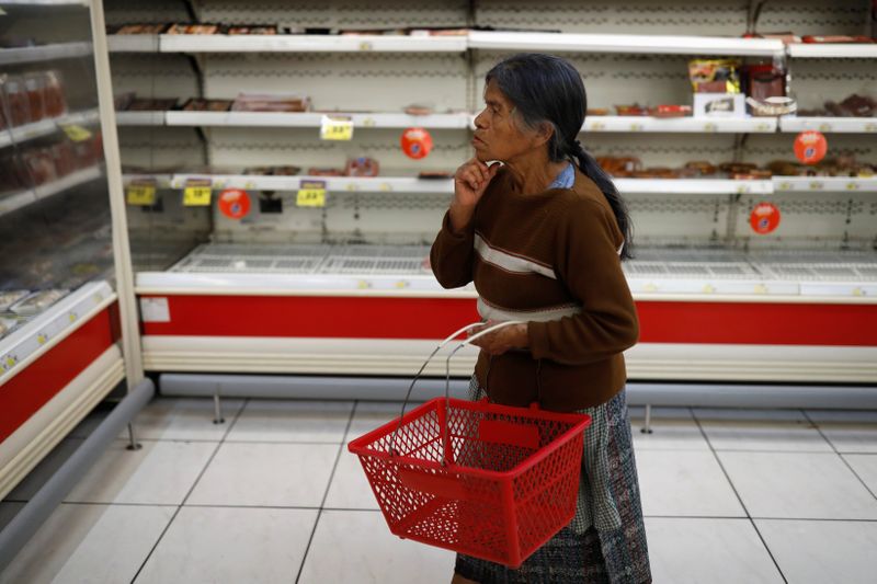 Una mujer mira estantes vacíos en un supermercado después de que el gobierno de Guatemala anunciara medidas para prevenir la propagación del coronavirus. 17 de marzo de 2020. REUTERS / Luis Echeverría