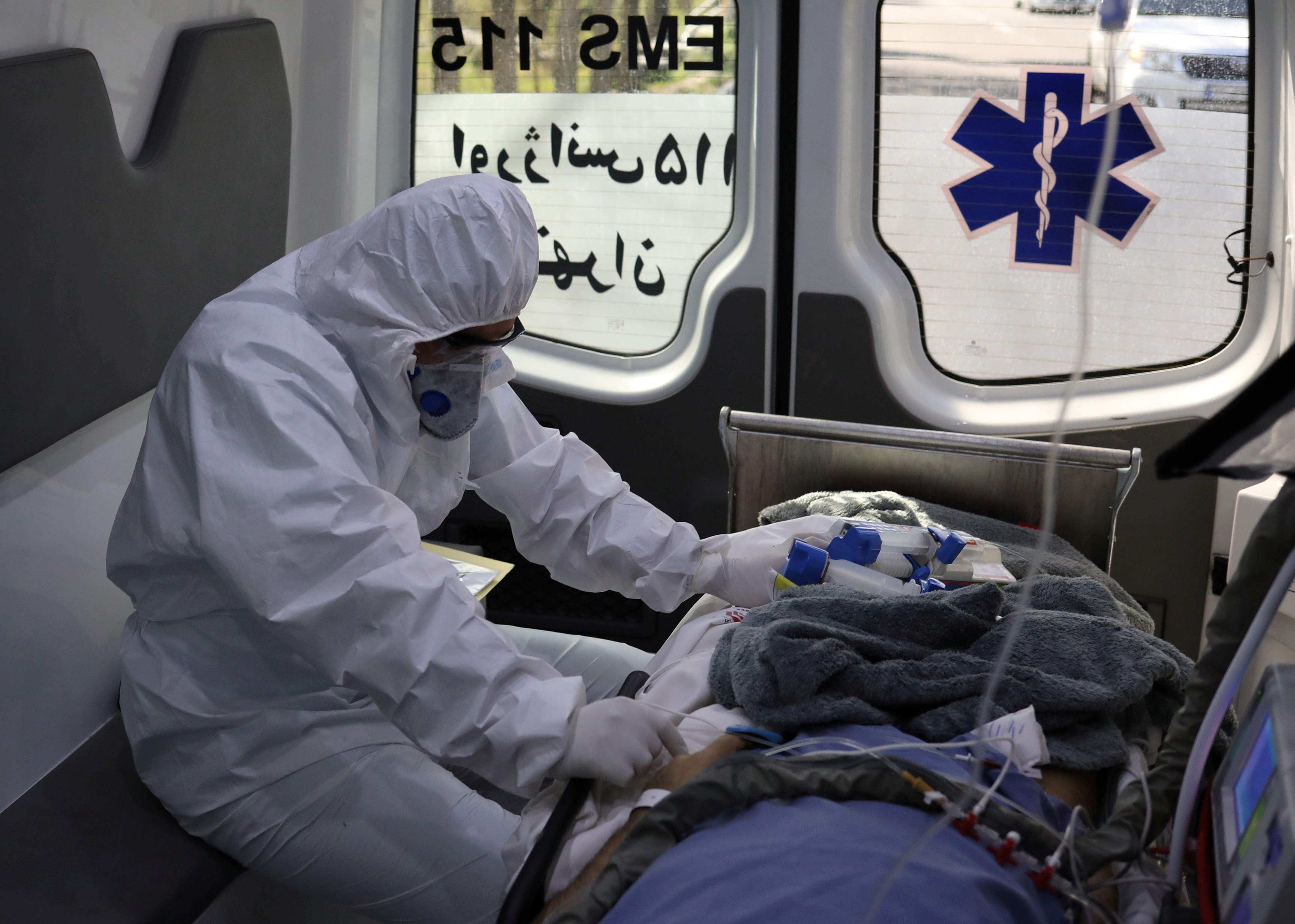 Un miembro del personal médico de emergencia con traje protector se sienta en una ambulancia mientras traslada a un paciente con coronavirus al Hospital Masih Daneshvari, en Teherán, Irán (REUTERS)