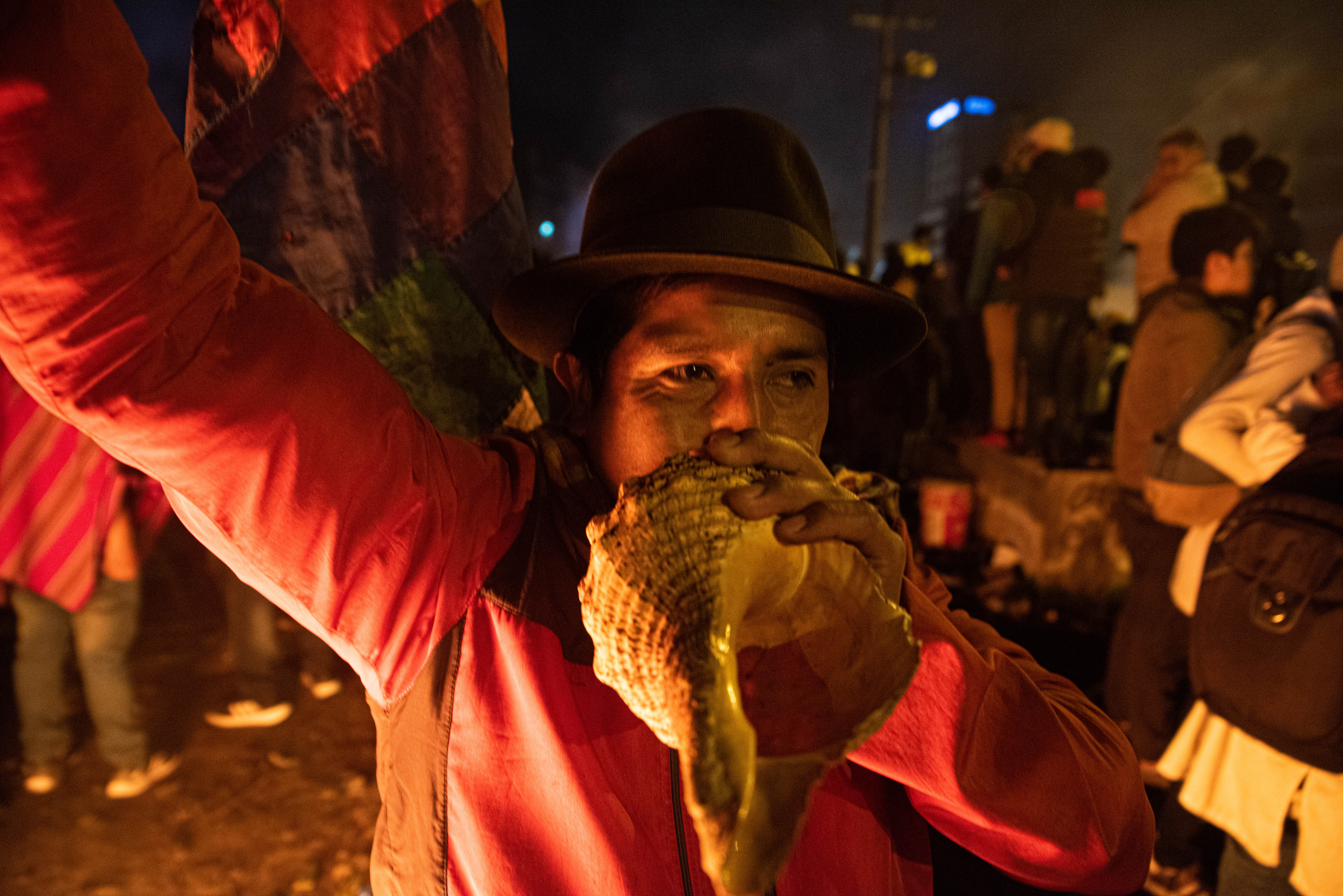 Un hombre toca una caracola para simbolizar el fin de la batalla campal que se libro entre la policía y miles de manifestantes en las calles de Quito y el resto del país