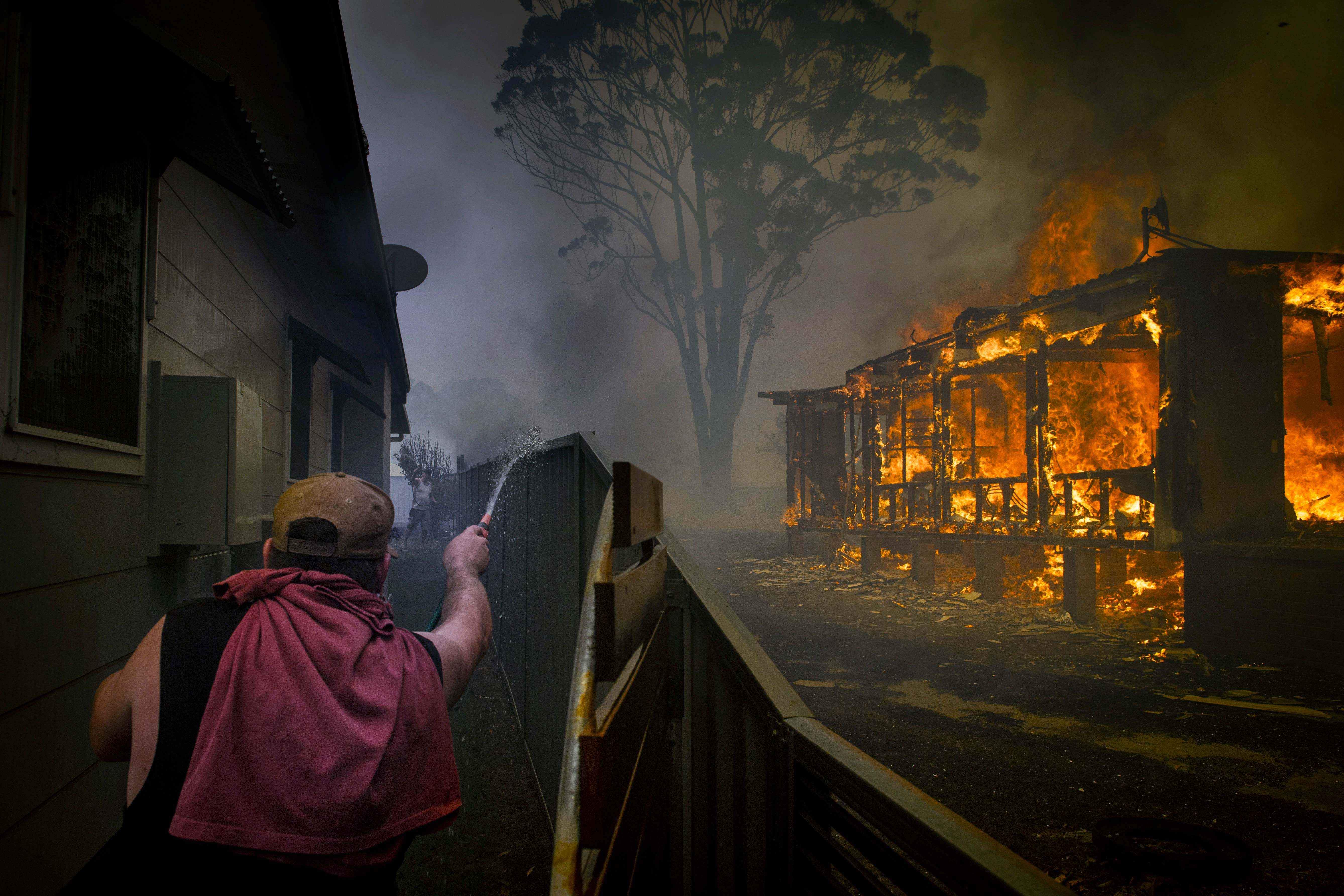 Un hombre trata de proteger su propiedad en Lake Conjola, Nueva Gales del Sur, Australia, en la víspera de Año Nuevo, el 31 de diciembre de 2019. (Matthew Abbott/The New York Times)