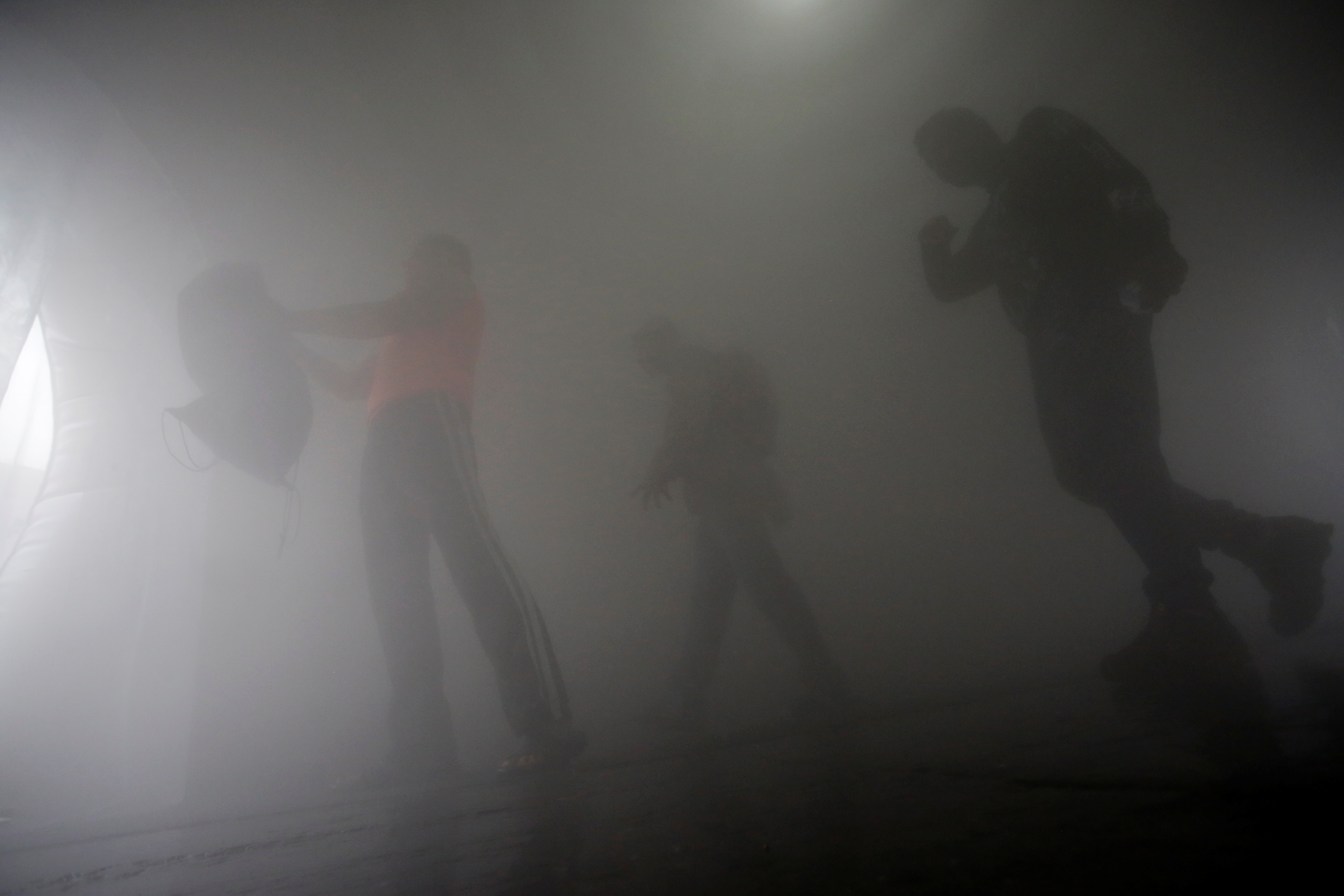People walk through a disinfection chamber installed on a sidewalk as part of the measures against the spreading of the coronavirus disease (COVID-19), in Escobedo, on the outskirts of Monterrey, Mexico March 29, 2020. REUTERS/Daniel Becerril