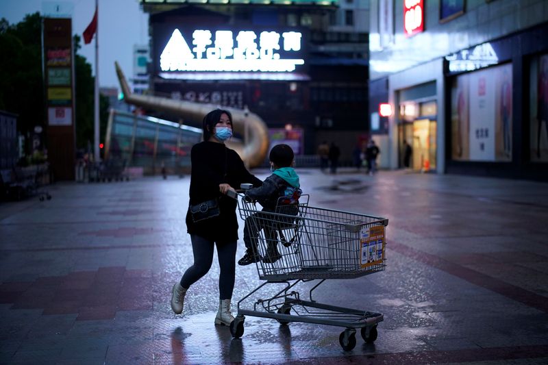 Una mujer con una máscara por el coronavirus empujando un carro de compras en Xianning, en la provincia china de Hubei. (REUTERS/Aly Song)