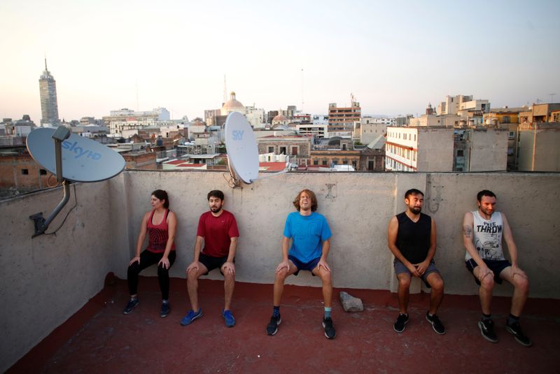 Personas en aislamiento realizan ejercicio en un techo
(REUTERS)