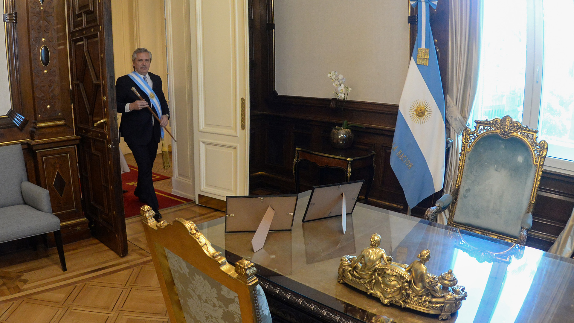 Alberto Fernández, con la banda y el bastón presidencial, se dirige por primera vez a sentarse en el sillón de Rivadavia