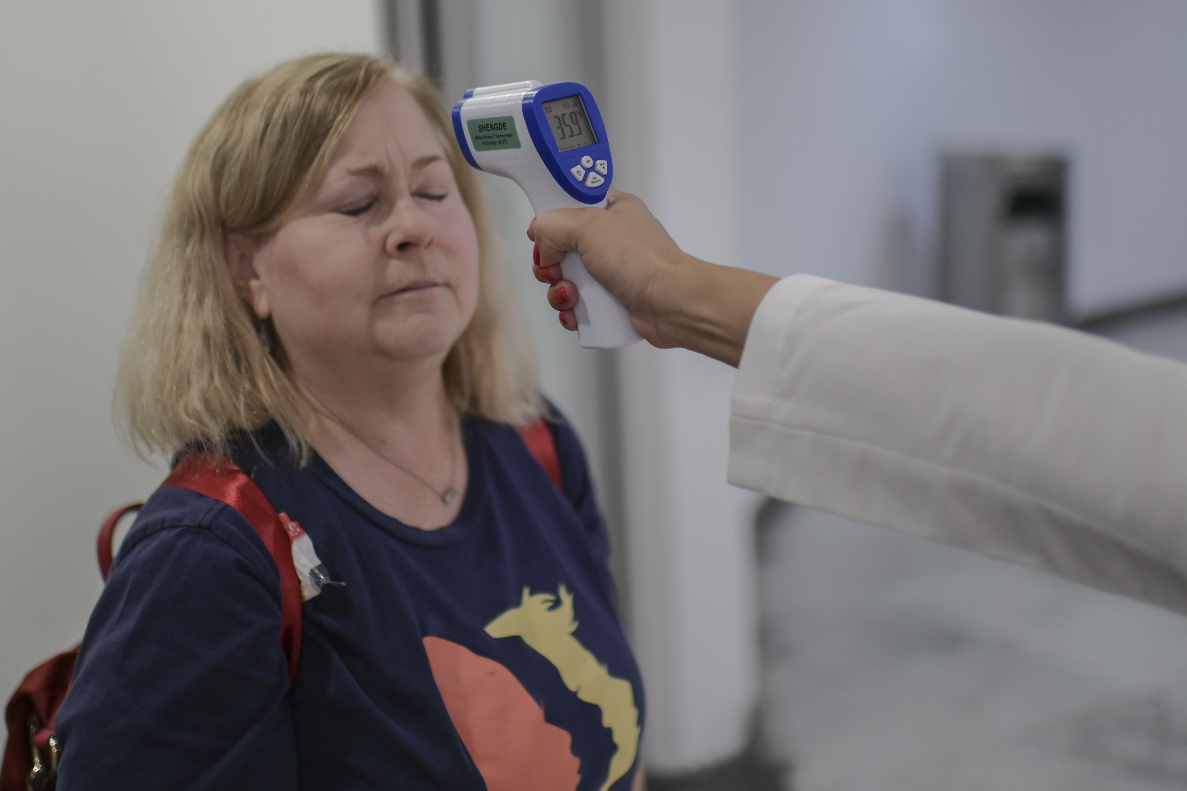 El personal de salud internacional verifica la temperatura de un pasajero como medida preventiva frente a la pandemia mundial de coronavirus COVID-19, en el aeropuerto internacional Benito Juárez en la Ciudad de México, el 13 de marzo de 2020.