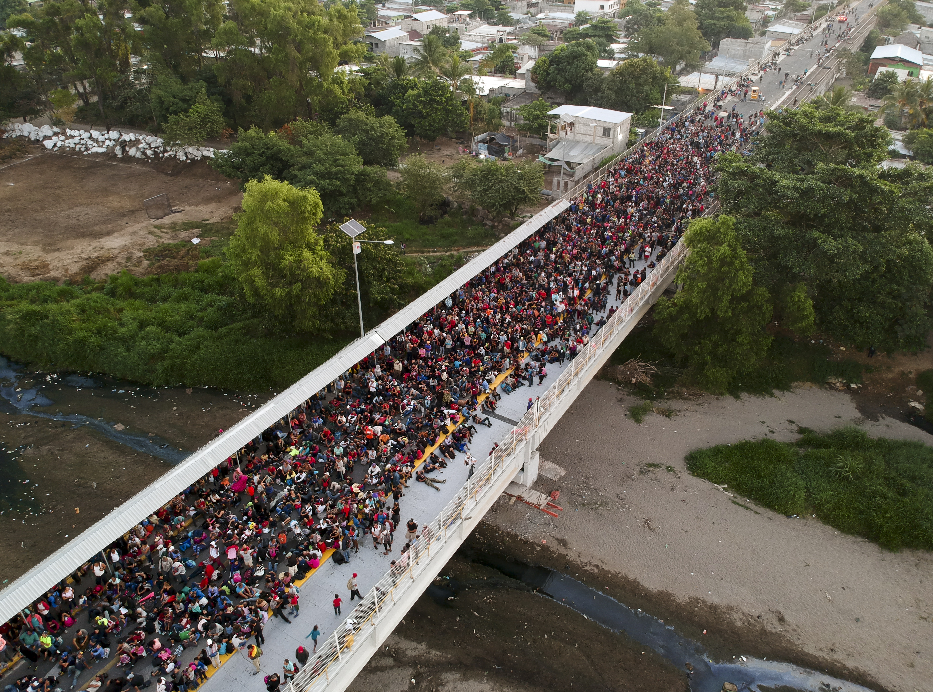 Miles de personas que compone la caravana migrante esperan sobre el puente internacional que divide México y Honduras (Foto: Carlos Alonzo /AFP)