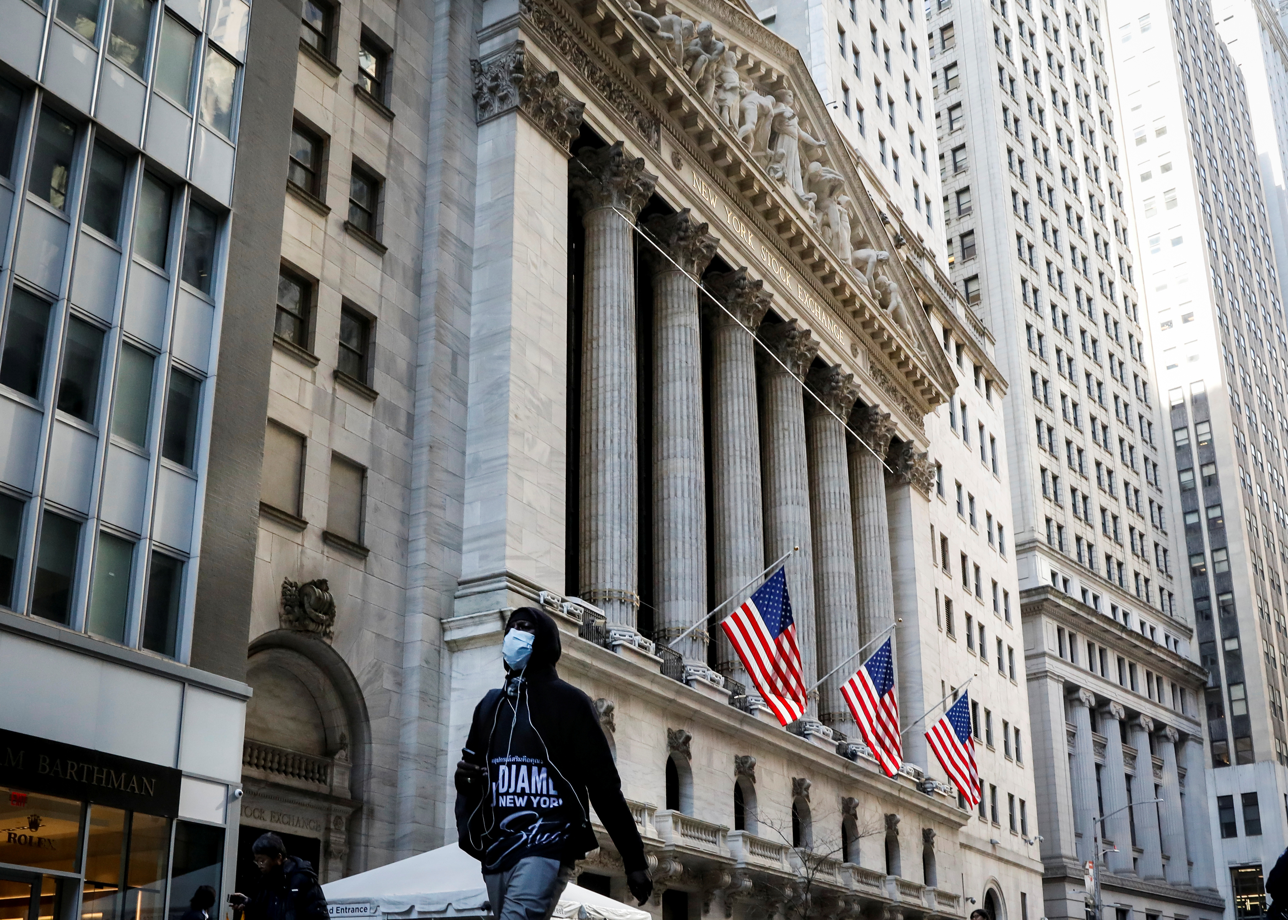 Un peatón con una mascarilla camina por la Bolsa de Nueva York, en Manhattan (Reuters)