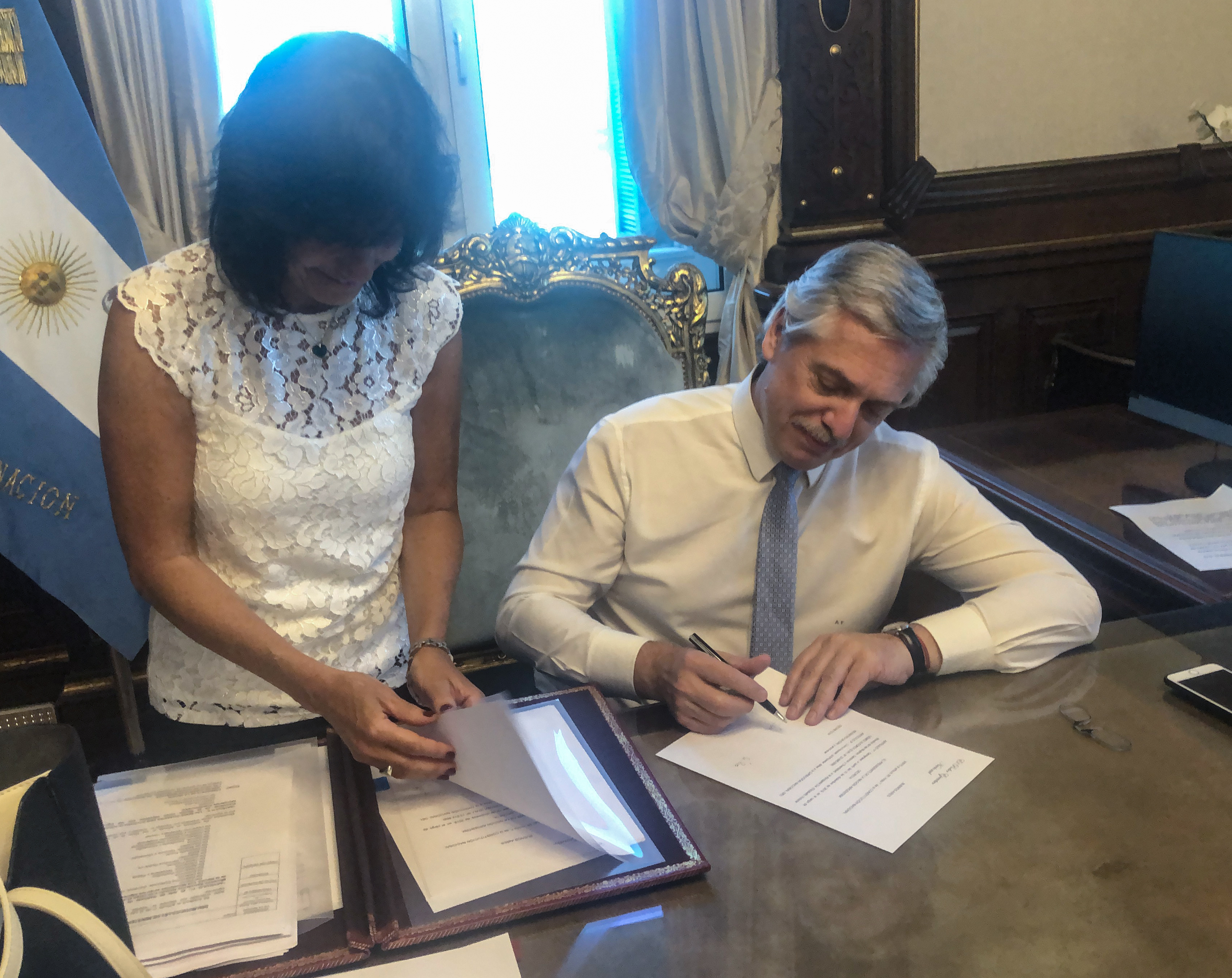 El presidente Alberto Fernández firmando las designaciones de sus ministros antes de la jura formal, junto a su secretaria Legal y Técnico Vilma Ibarra