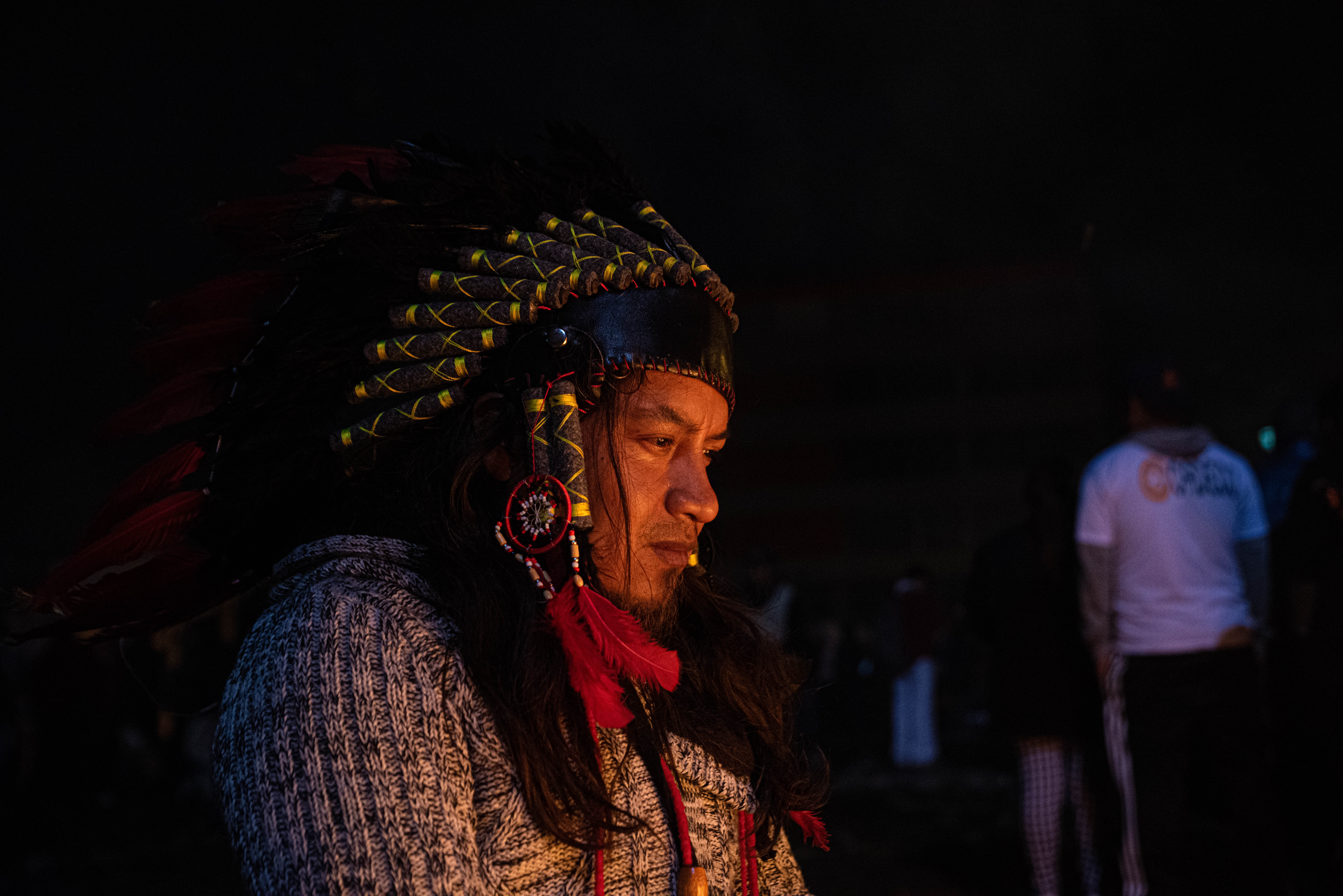 Un hombre con vestimenta tradicional aborigen en medio de los festejos en las calles de Quito.