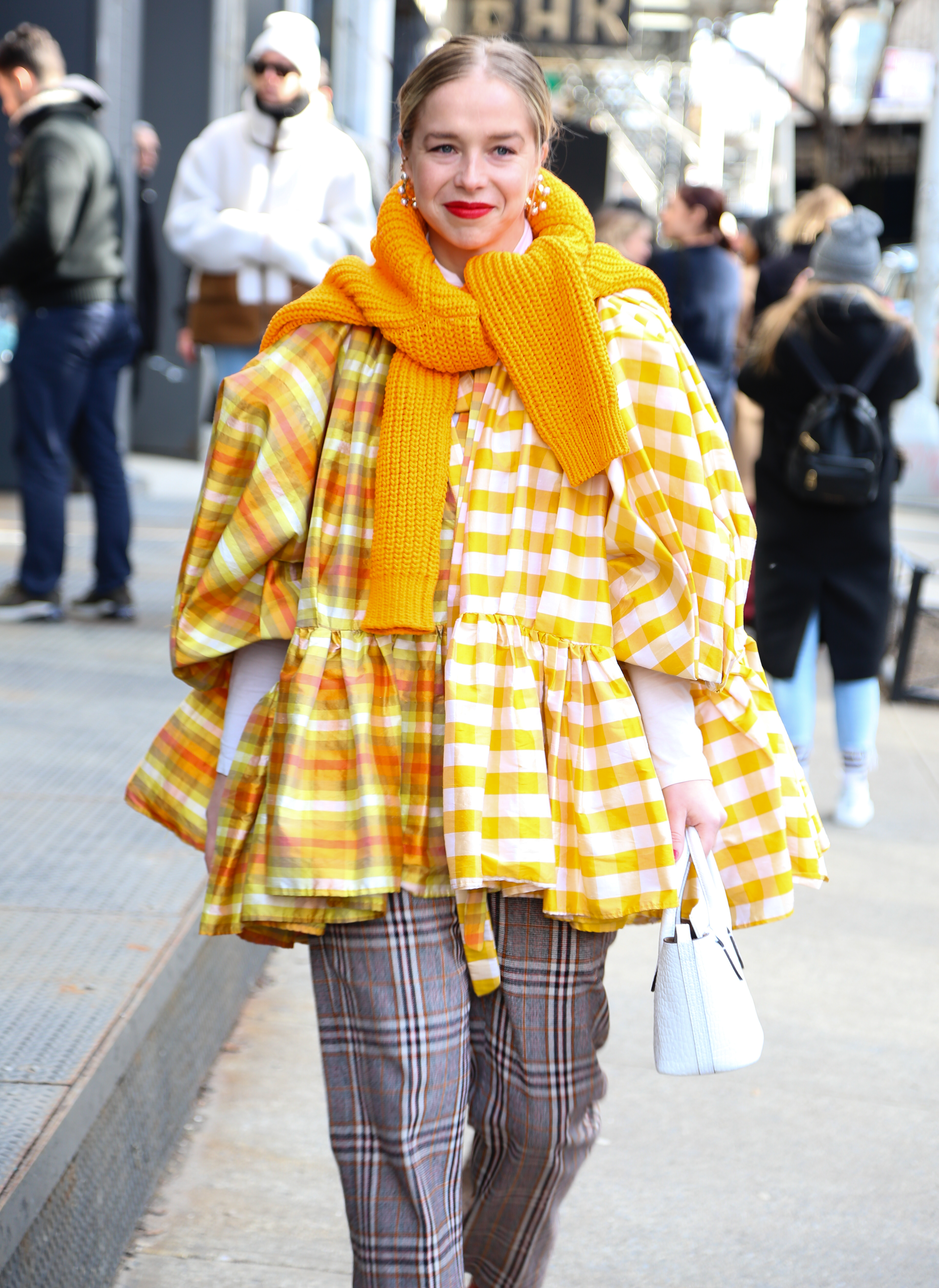 Cuadros alert. Blusa oversized en amarillo y blanco cuadrillé, combinada con pantalón príncipe de gales. Completó su outfit para el NYFW con una gran bufanda tejida