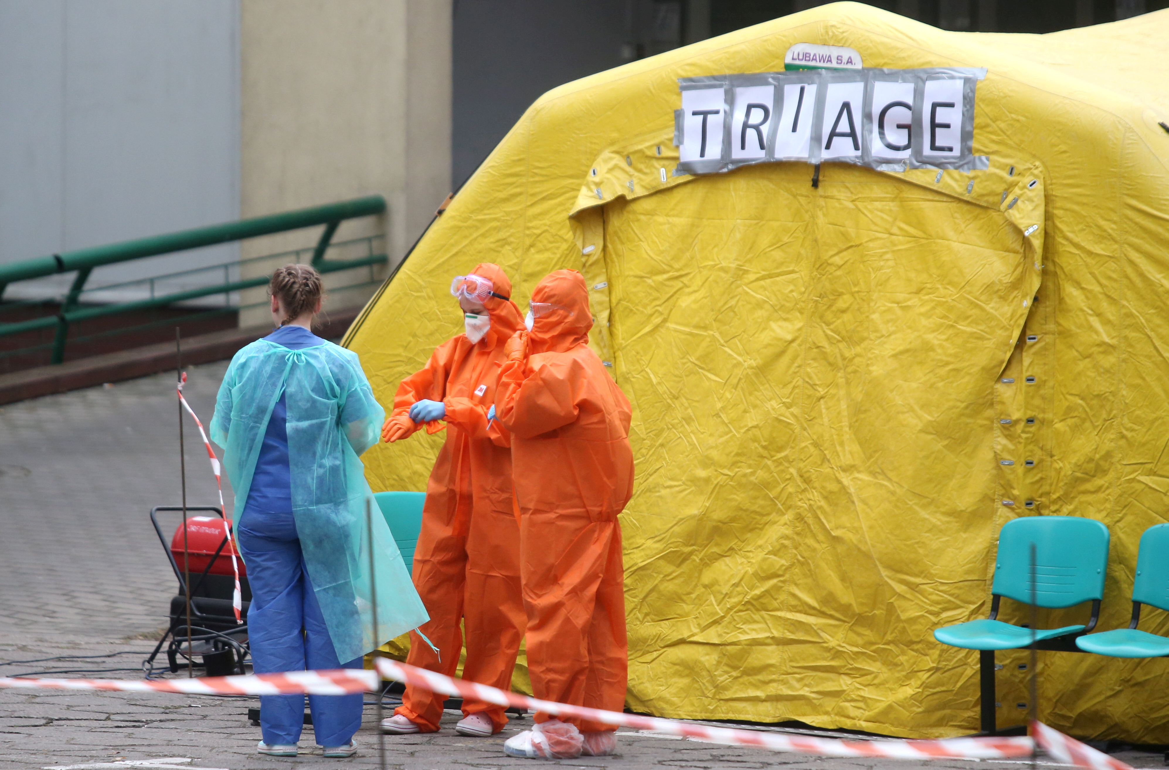 Los médicos esperan afuera de una tienda especial durante el brote de la enfermedad afuera de un hospital en Varsovia, Polonia (REUTERS)