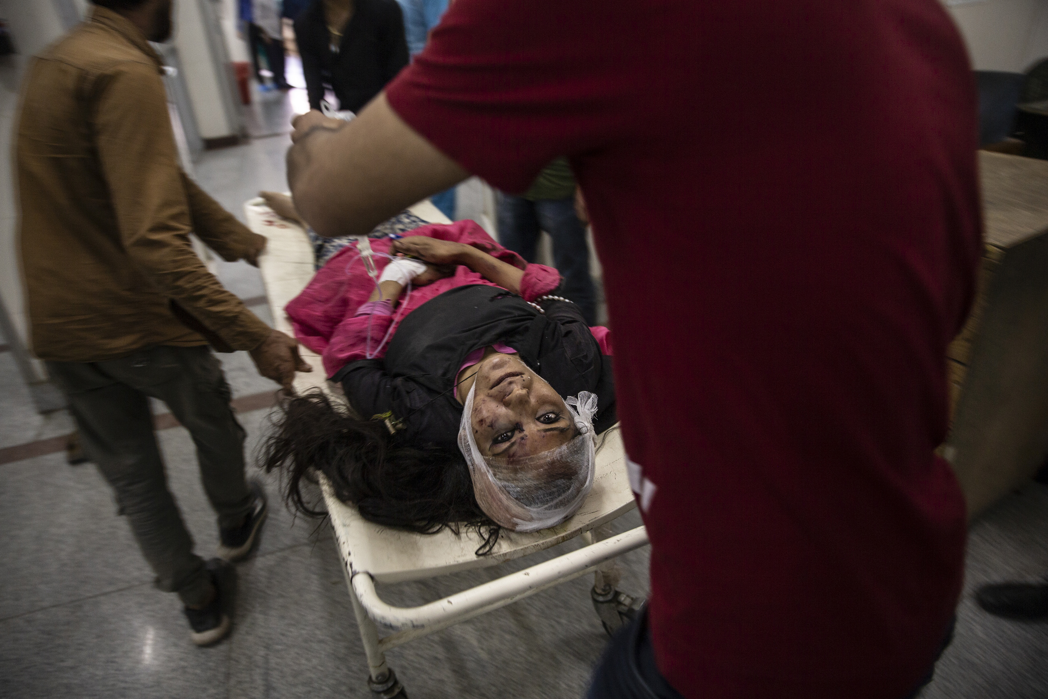 Una mujer herida es llevada en una camilla para recibir tratamiento después de ser herida en un accidente de autobús, en un hospital local en Srinagar, Cachemira controlada por la India, el 27 de junio de 2019. Un minibús que llevaba estudiantes a un picnic cayó en una garganta a lo largo de una carretera del Himalaya. en Cachemira (Foto AP / Dar Yasin)