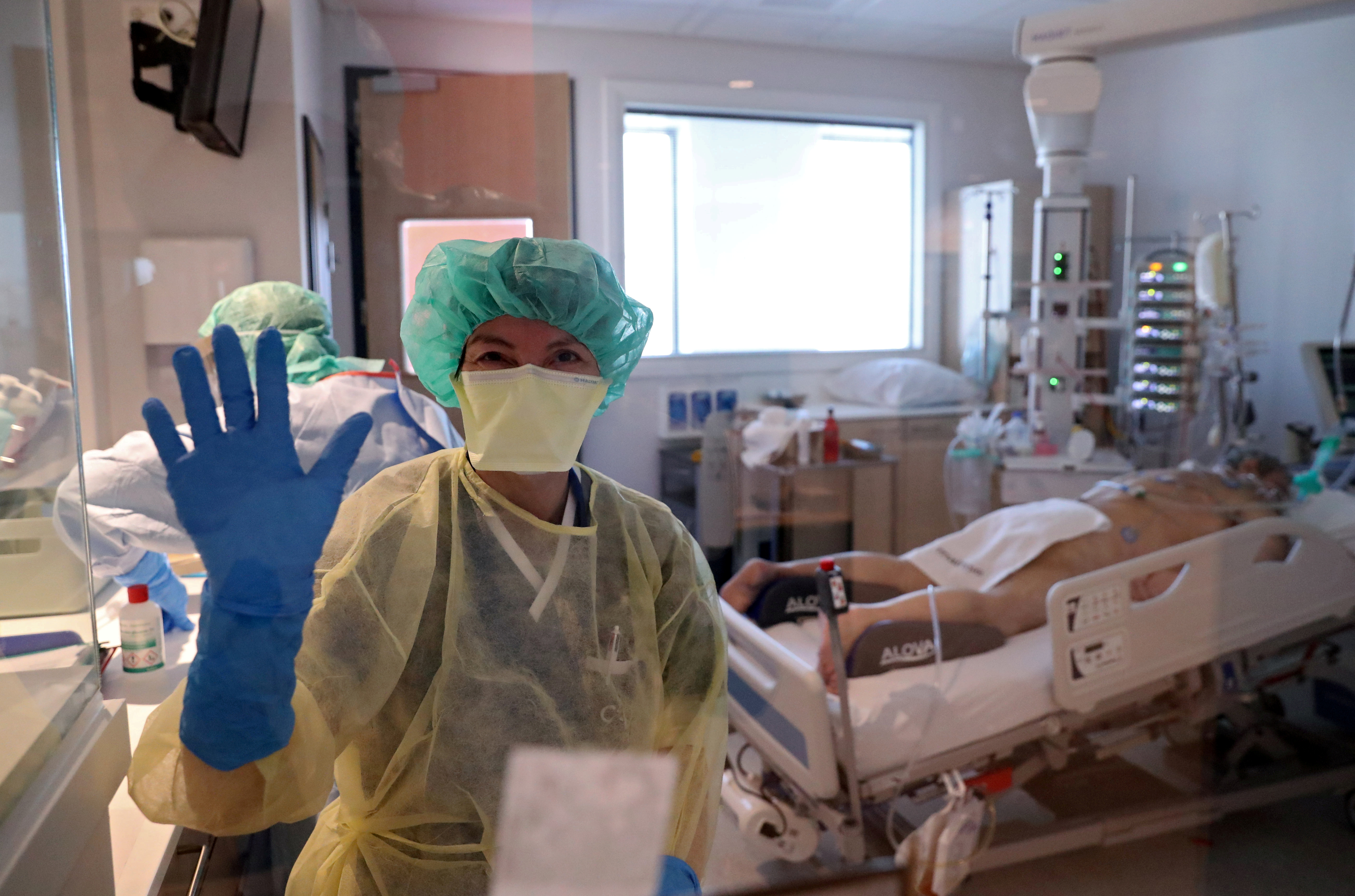 Una médica saluda a la cama mientras trabaja en una clínica de Bélgica (REUTERS/Yves Herman)