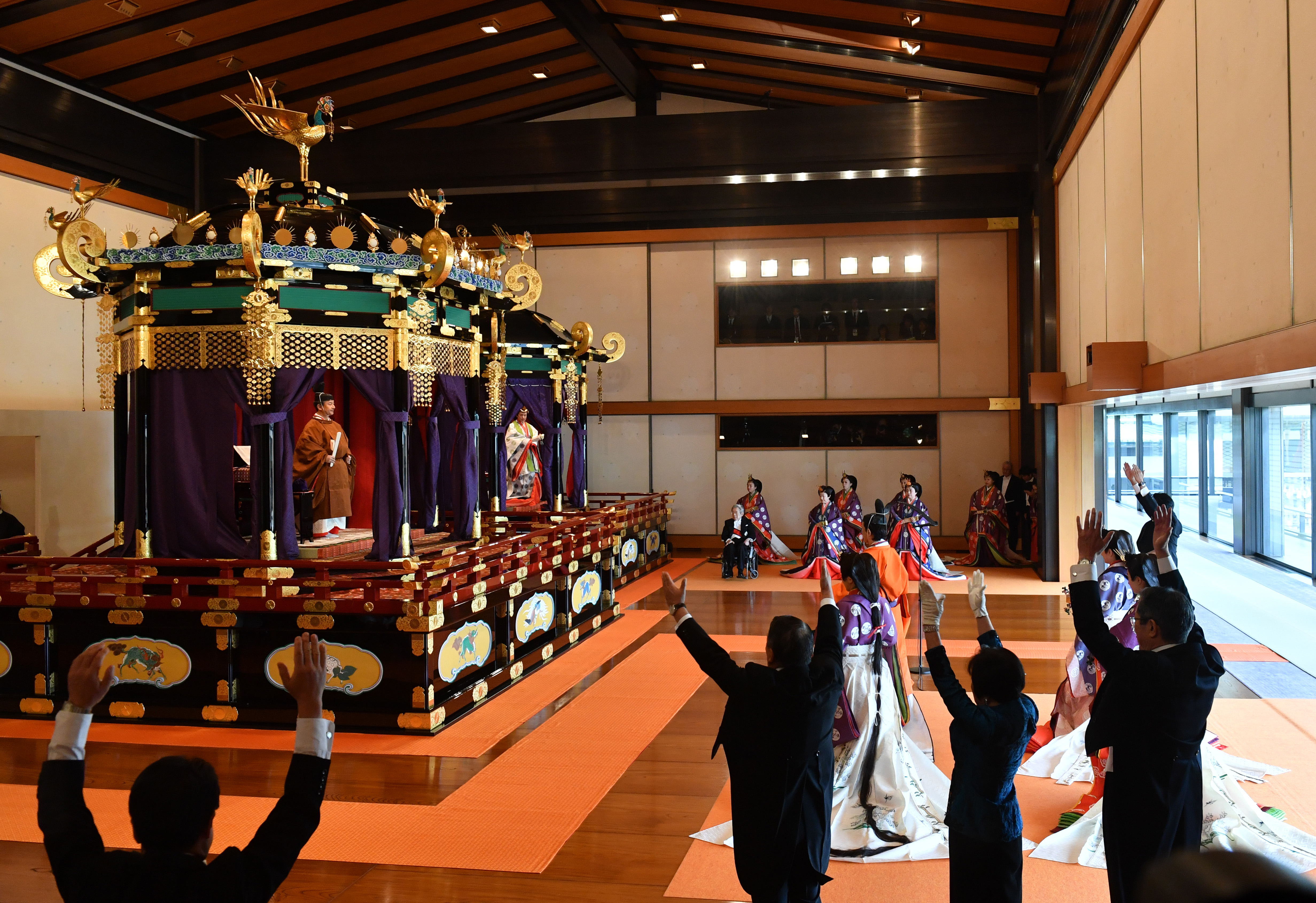 El primer ministro de Japón, Shinzo Abe (derecha), grita tres veces "Banzai" por el emperador Naruhito (arriba a la izquierda ) y la emperatriz Masako durante la ceremonia de entronización donde el emperador proclama oficialmente su ascensión al Trono de Crisantemo en el Palacio Imperial de Tokio (AFP) 