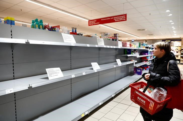 FOTO DE ARCHIVO. Una mujer mira un estante vacío con un letrero que anuncia el racionamiento de papel higiénico a un paquete por persona, en un supermercado de la cadena Rewe, en Potsdam, Alemania. 20 de marzo de 2020. REUTERS/Michele Tantussi.