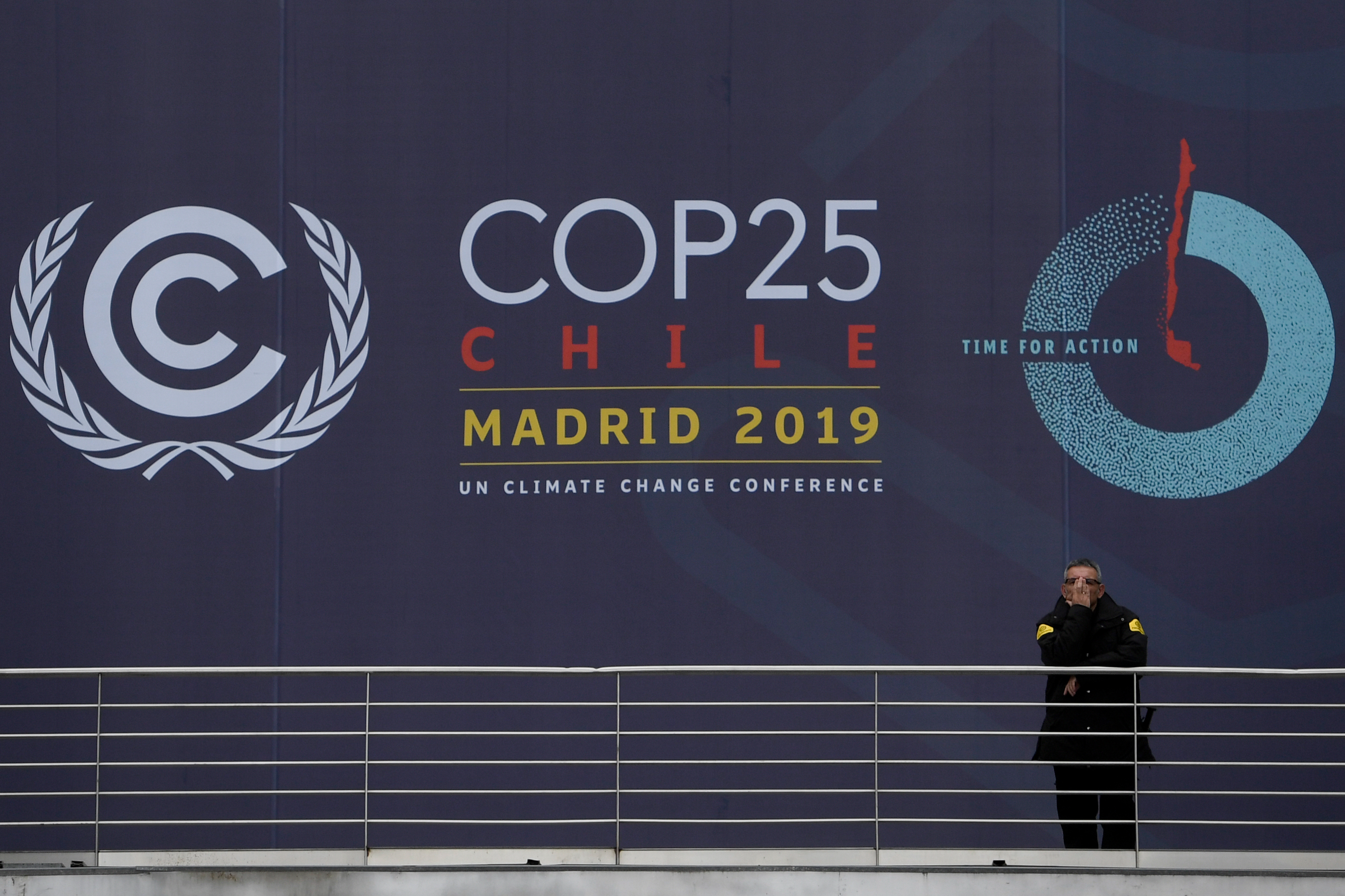 Un guardia de seguridad se para frente al estandarte de la cumbre climática COP25, en el centro de congresos IFEMA en Madrid el 30 de noviembre de 2019, (Foto de PIERRE-PHILIPPE MARCOU / AFP )