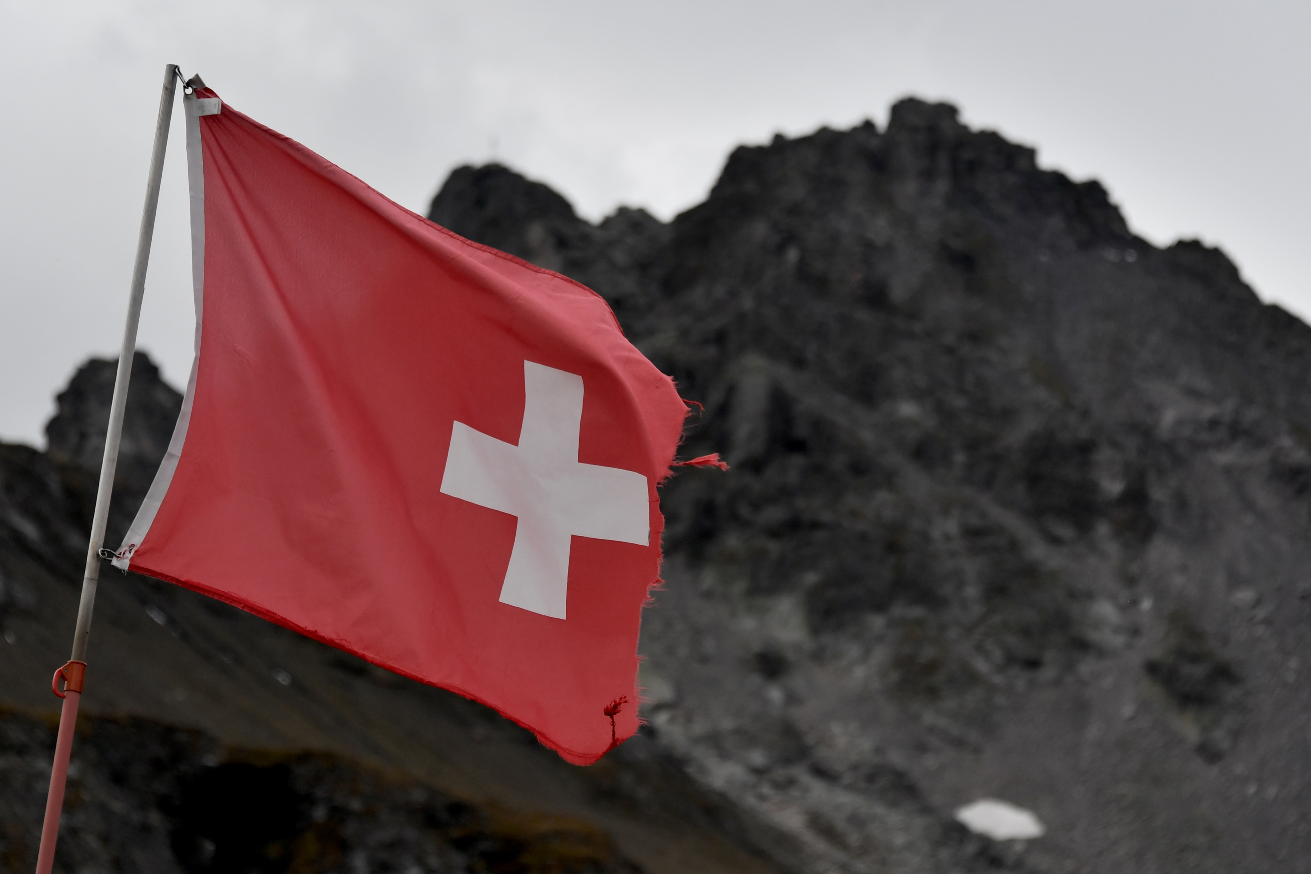 Una bandera nacional suiza ondea durante una ceremonia para conmemorar la 'muerte' del glaciar Pizol (Pizolgletscher). (Foto por Fabrice COFFRINI / AFP)