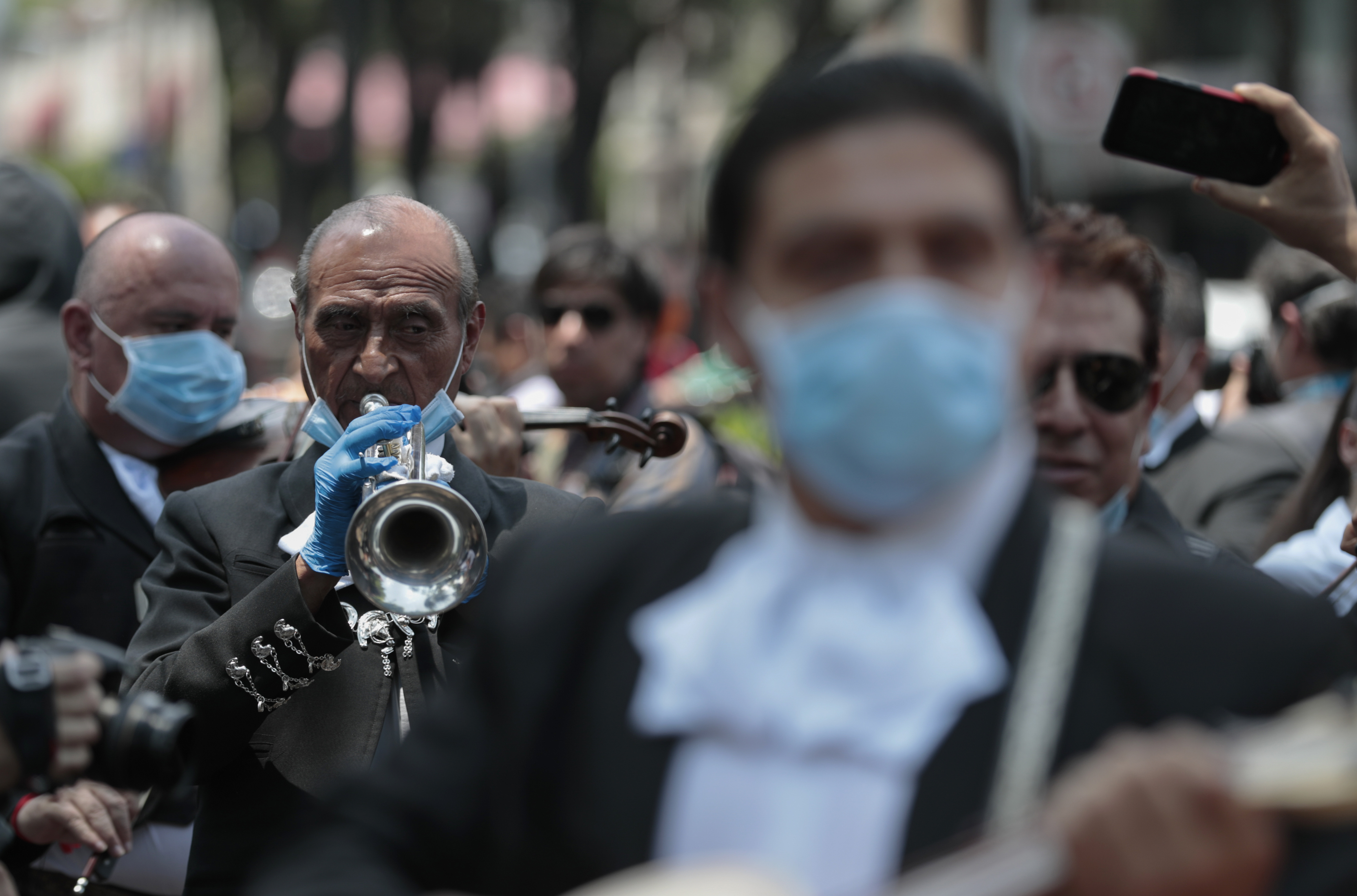 Los mariachis usan equipo de protección en medio de la propagación del nuevo coronavirus mientras tocan una