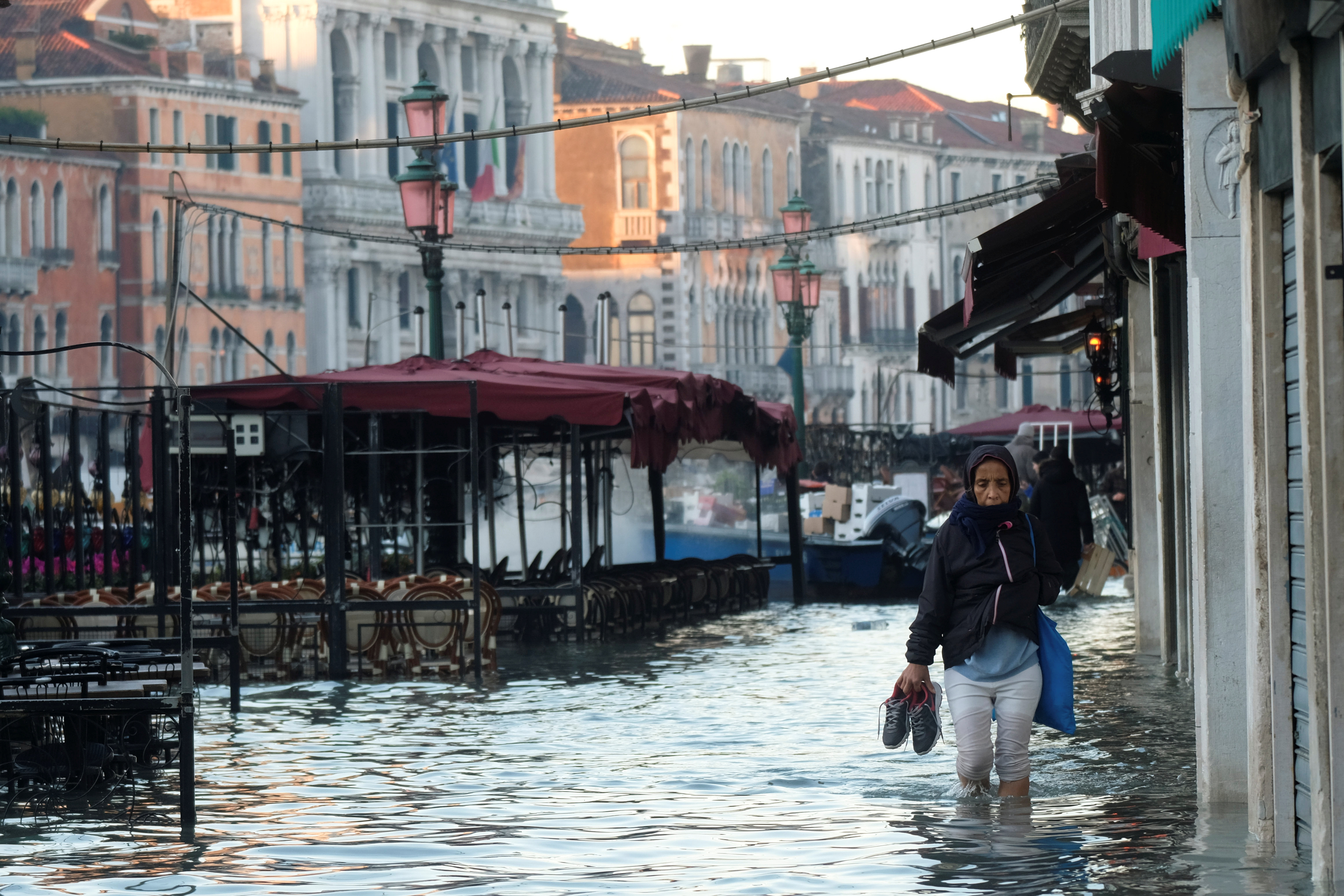 Una mujer camina por una calle inundada (REUTERS/Manuel Silvestri)