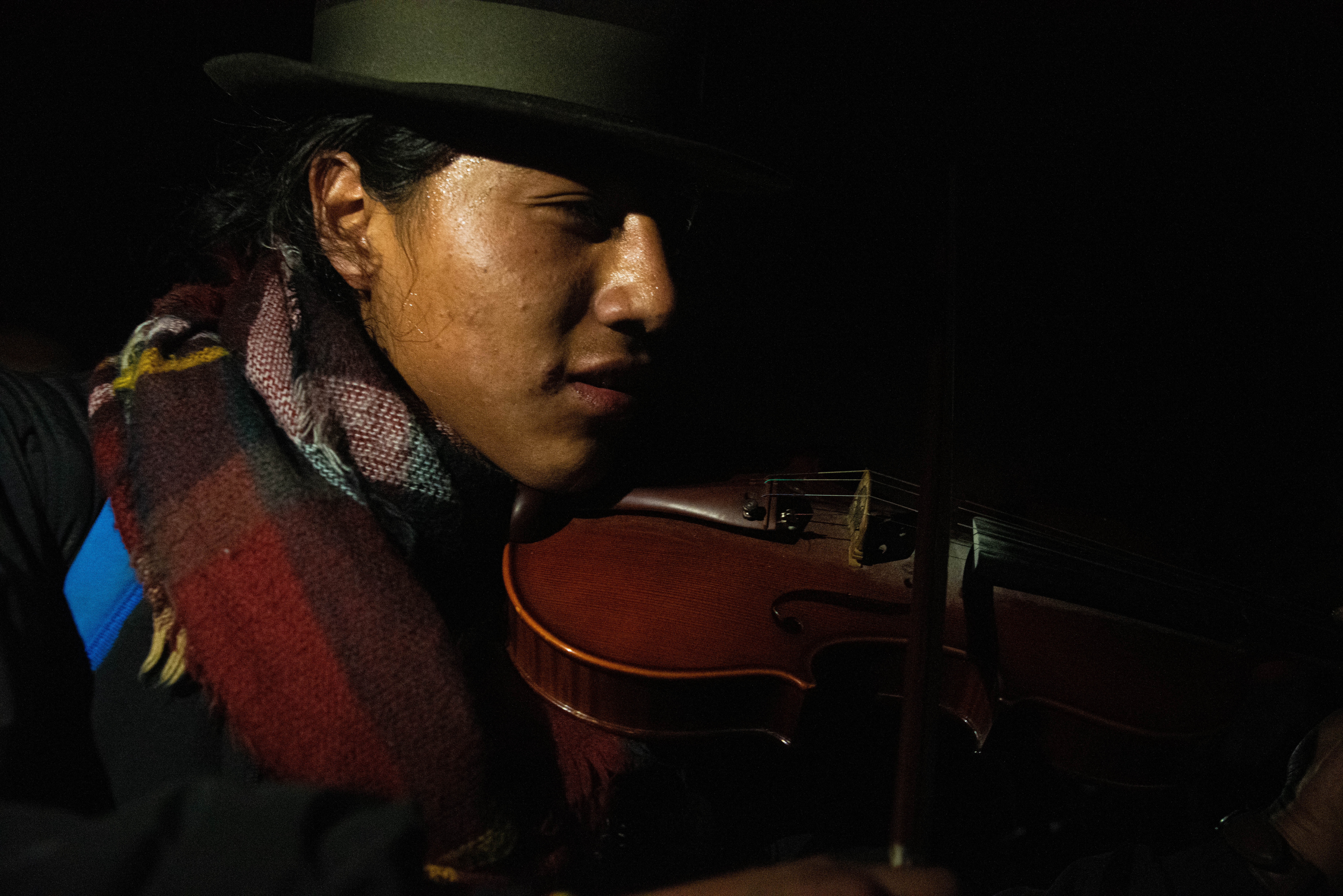 Un mujer indígena toca su violín para celebrar en las calles de Quito.