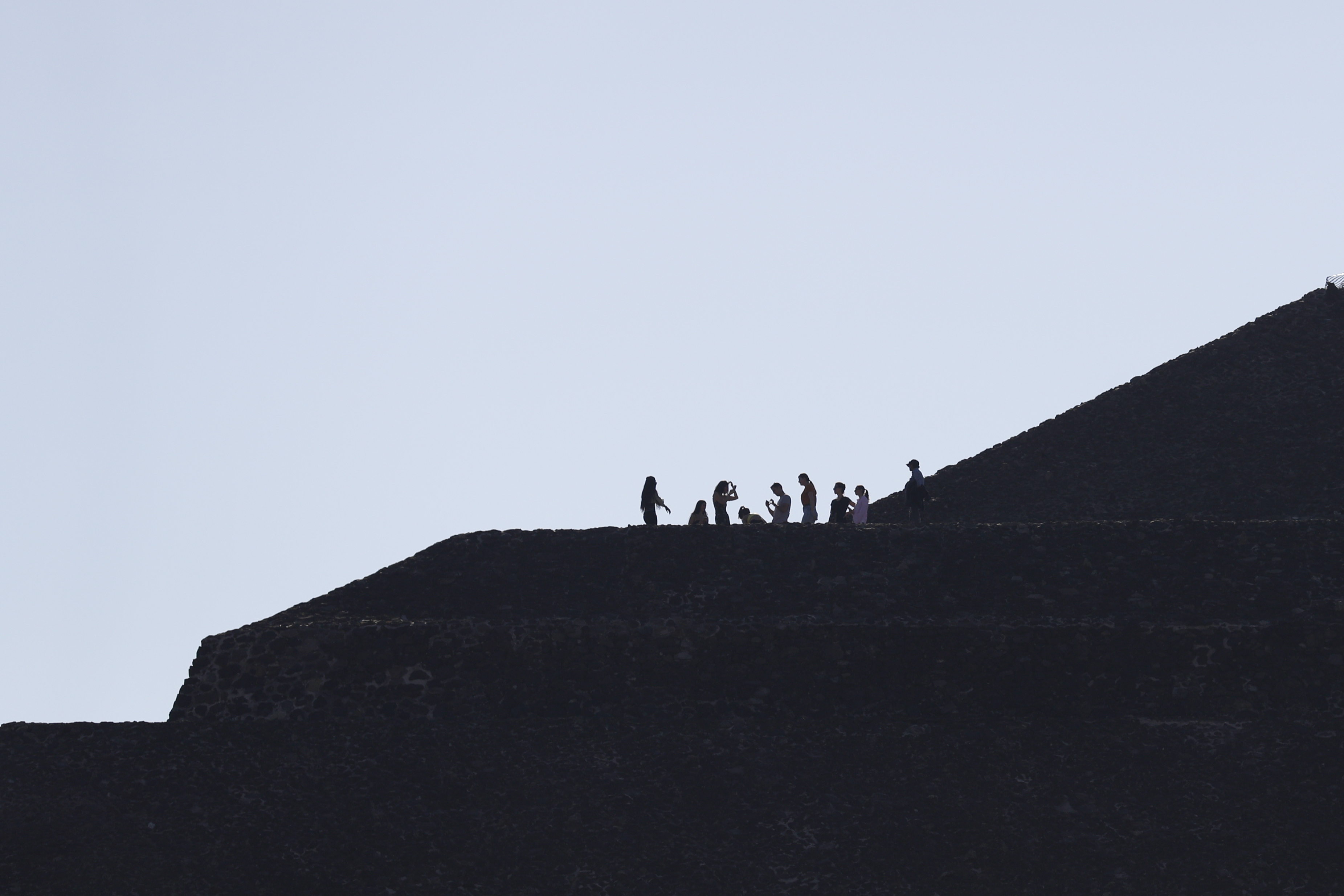Los visitantes se paran en una planicie sobre la Pirámide del Sol en Teotihuacan, México, el jueves 19 de marzo de 2020.