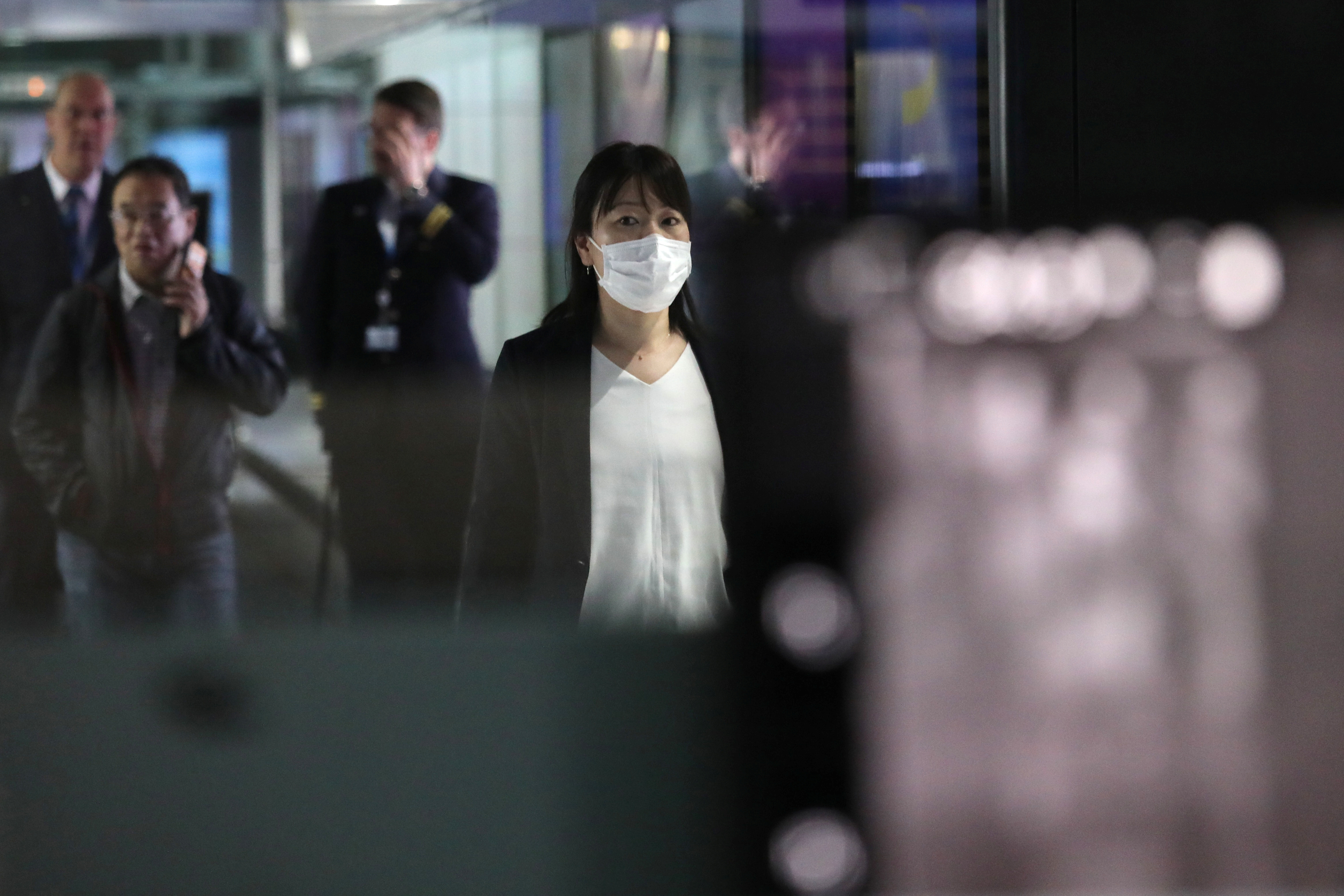 Una mujer con máscara pasa por el punto de detección térmica en la terminal de llegadas internacionales del aeropuerto internacional de Kuala Lumpur en Sepang, Malasia, el 21 de enero de 2020. REUTERS / Lim Huey Teng