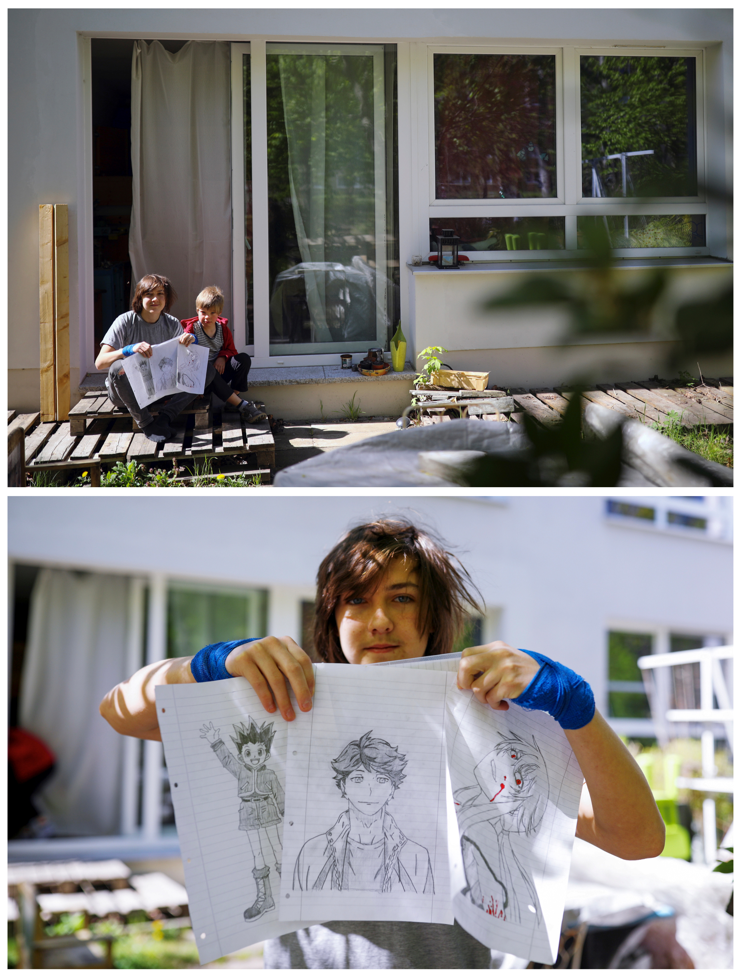 Willem Vorbau, 14 y Floris, 8, posan para una foto mientras sostienen dibujos que hicieron durante el brote de coronavirus, fuera de su departameno en Berlín, Alemania, el 19 de abril de 2020.