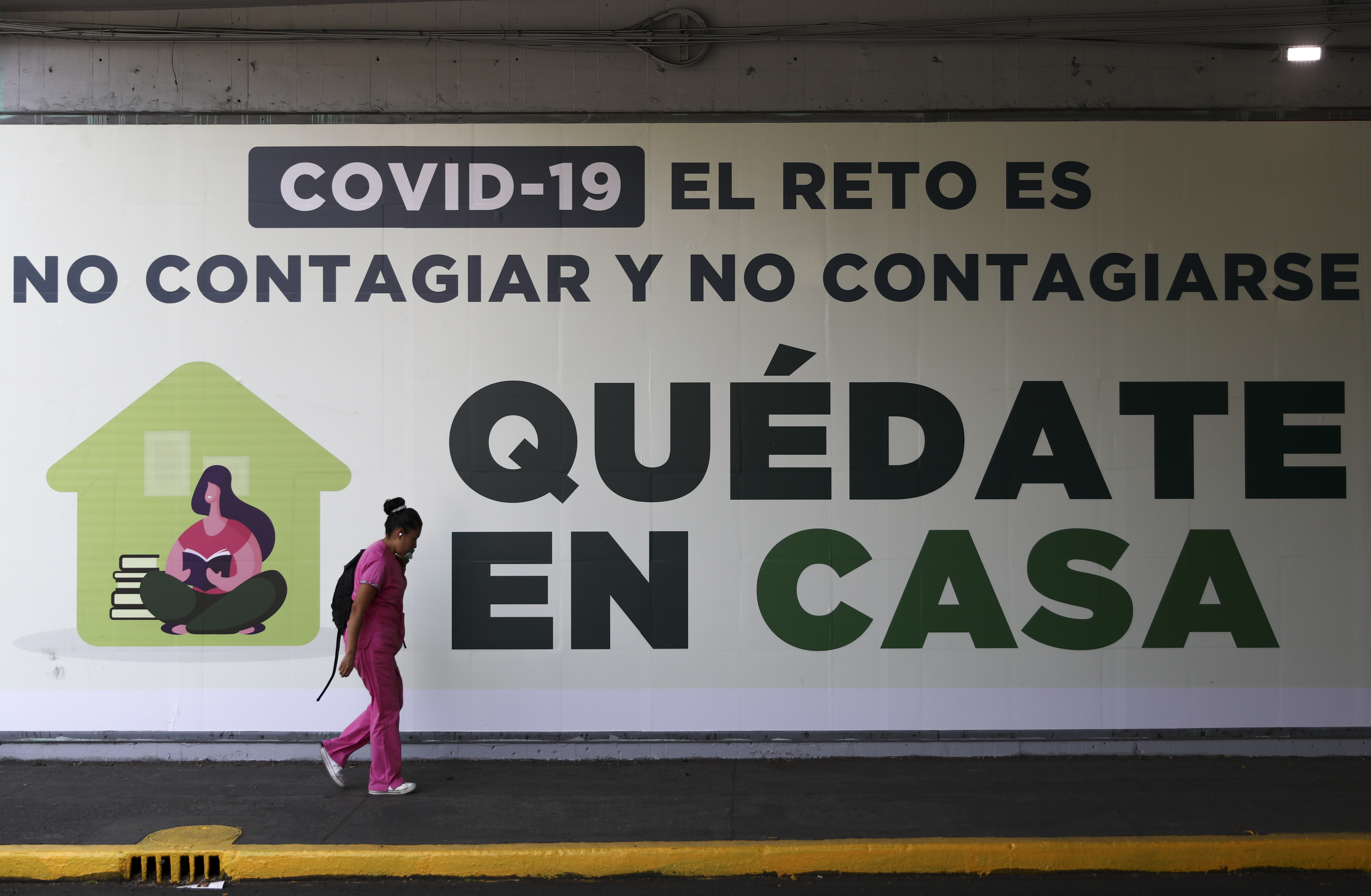 Una mujer pasa junto a un letrero que dice: