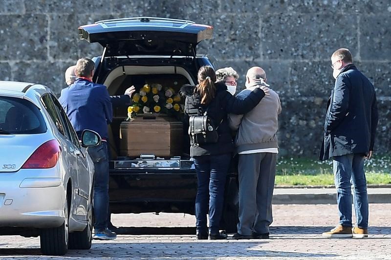 Familiares de una persona que murió por coronavirus llegan a un cementerio en Bérgamo para su sepelio