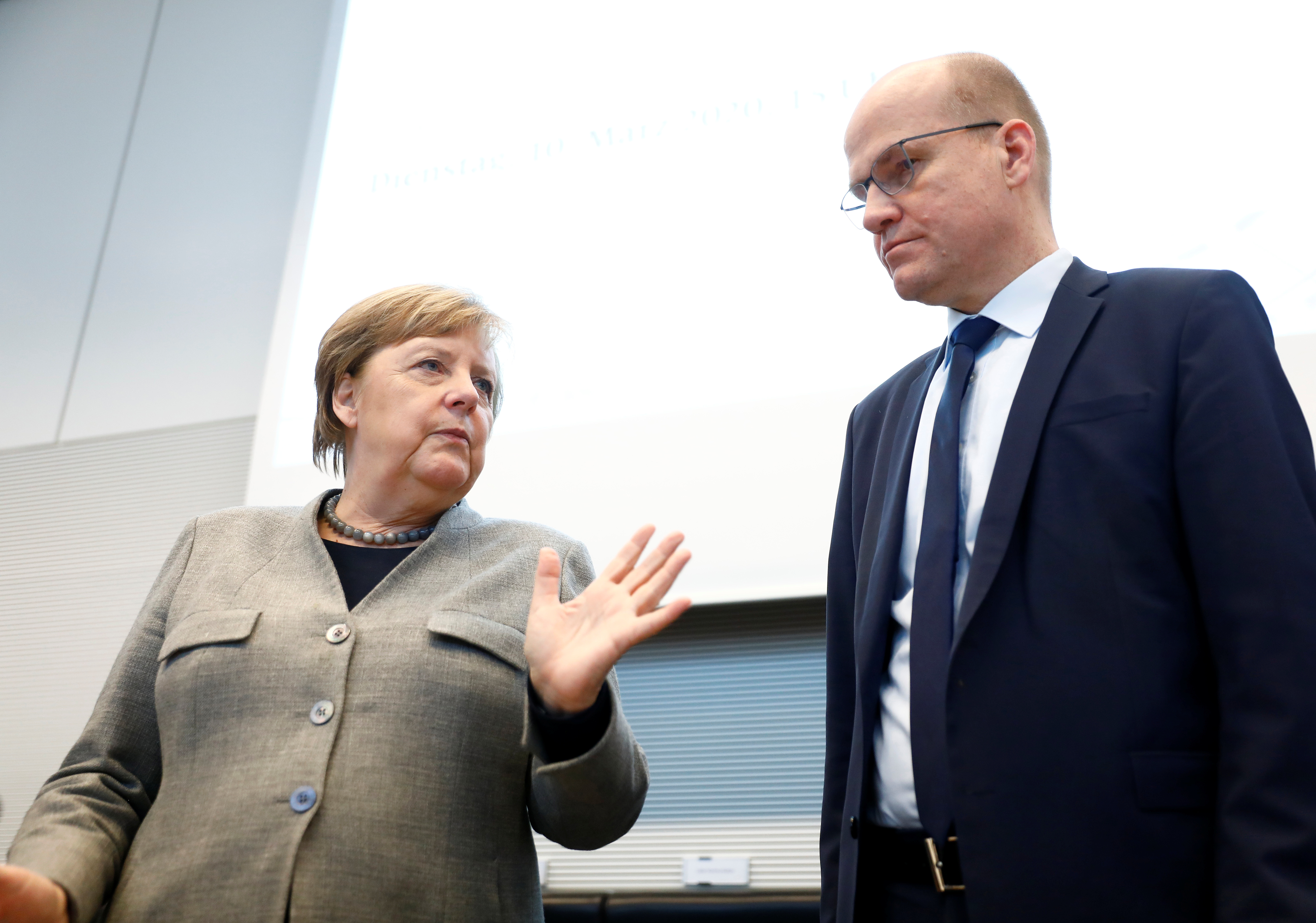 Angela Merkel y el lider de la Unión Demócratacristiana (CDU), Ralph Brinkhaus, coversan antes de la reunión en el Parlamento de este martes ( REUTERS/Michele Tantussi)