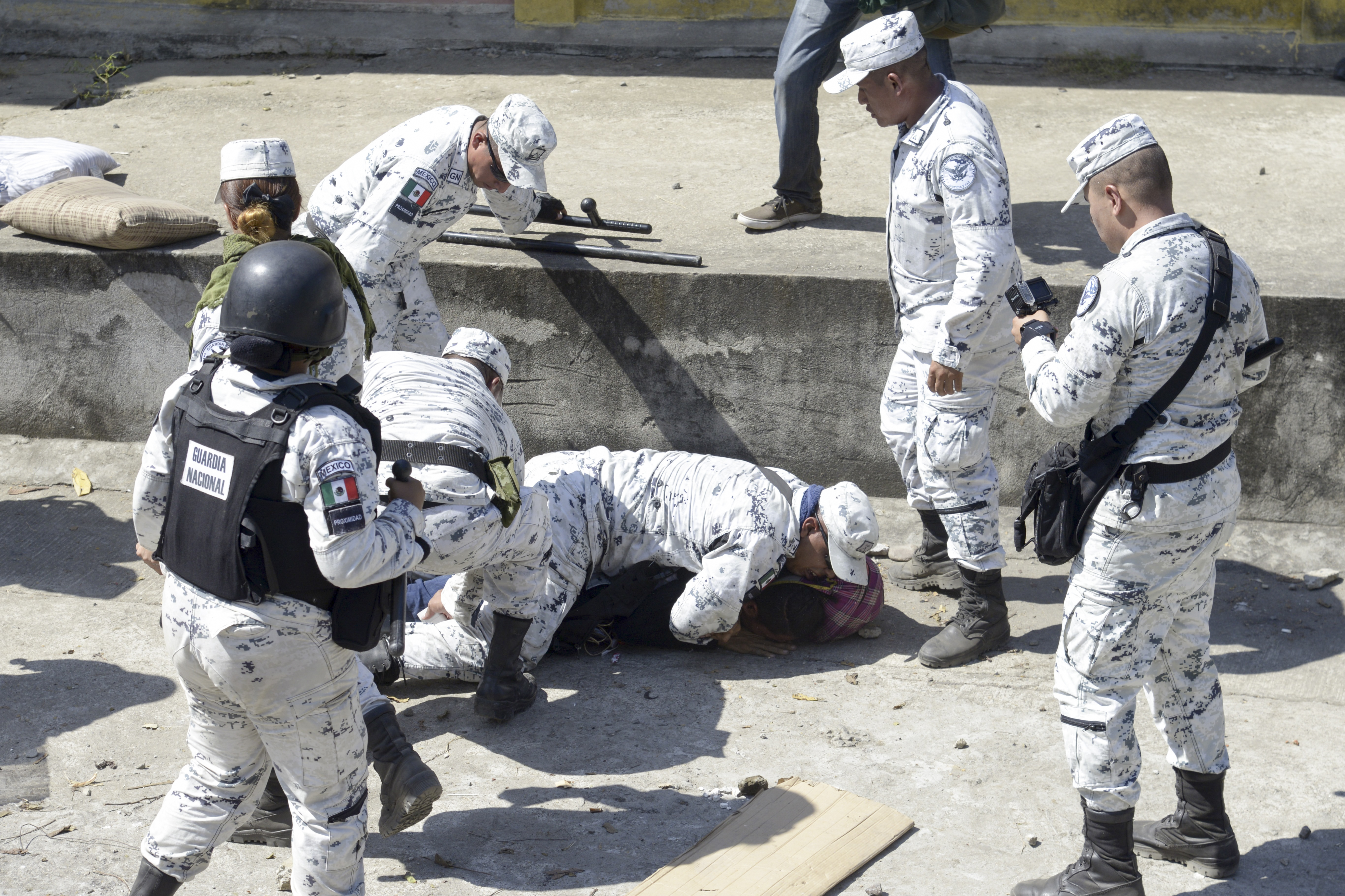 Migrante siendo sometido por elementos de la Guardia Nacional al intentar cruzar por la fuerza la frontera entre México y Guatemala (Foto: Isaac Guzman/AFP)