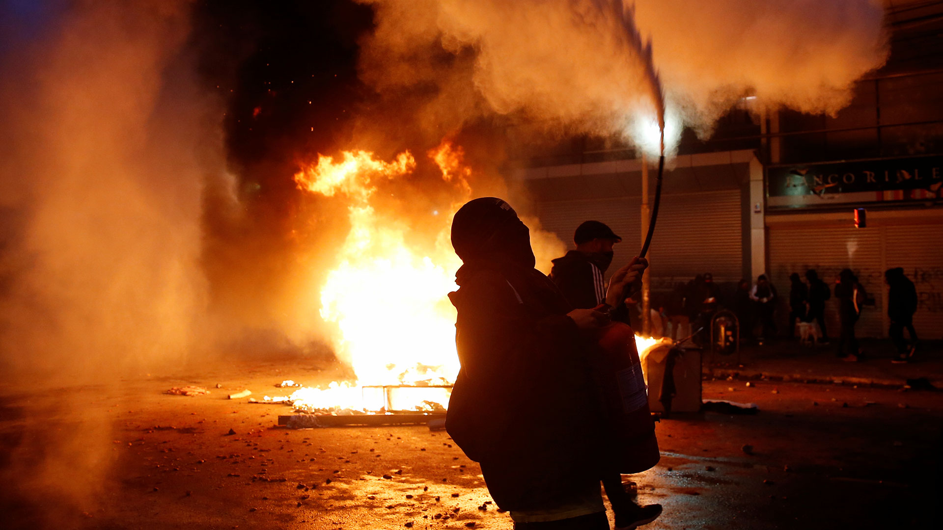 Manifestantes al rededor de una calle en llamas en Valparaíso.