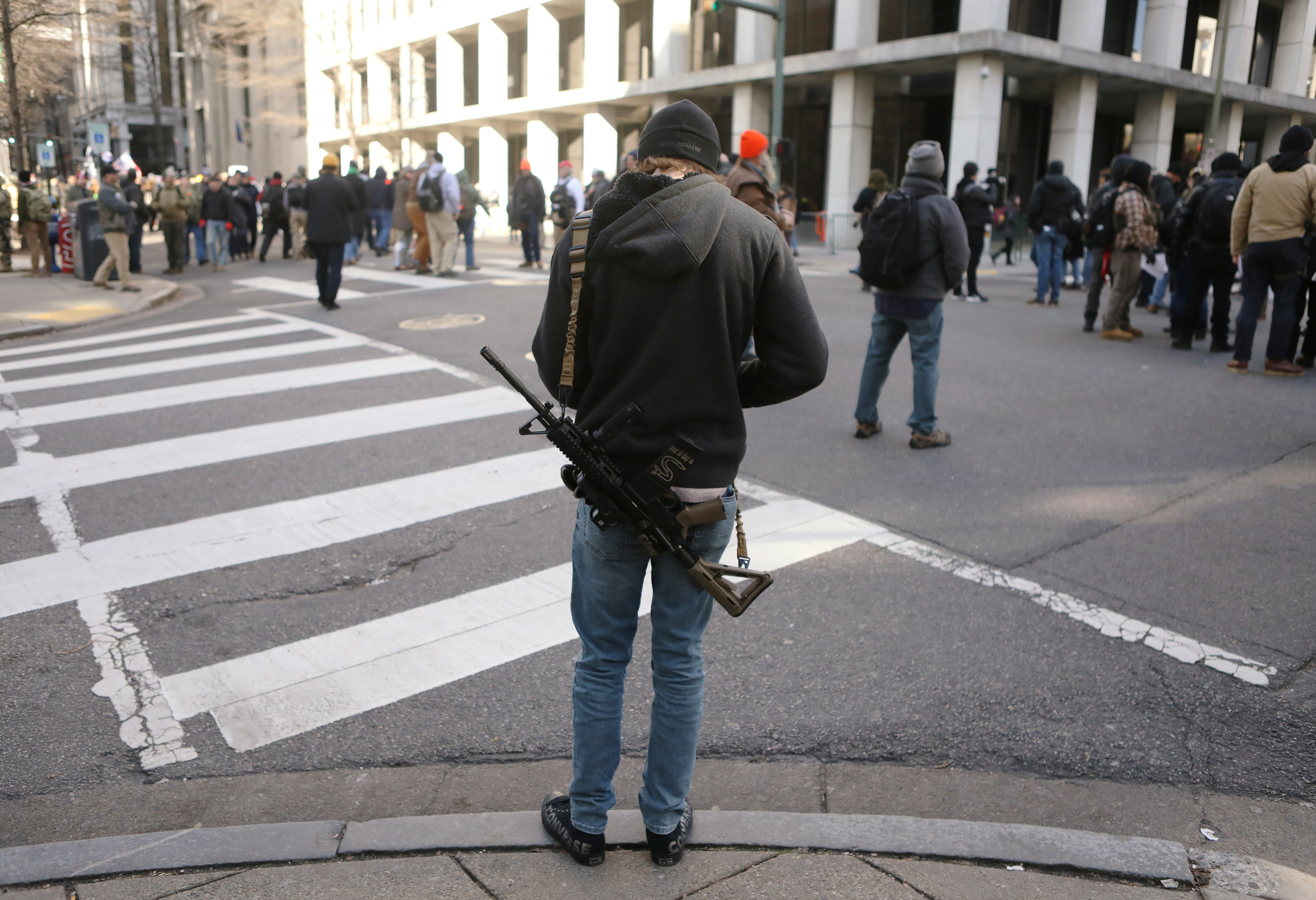 Otro fusil de la familia del AR-15, uno de los más populares en Estados Unidos, cuelga del hombro de un asistente (REUTERS/Jim Urquhart)