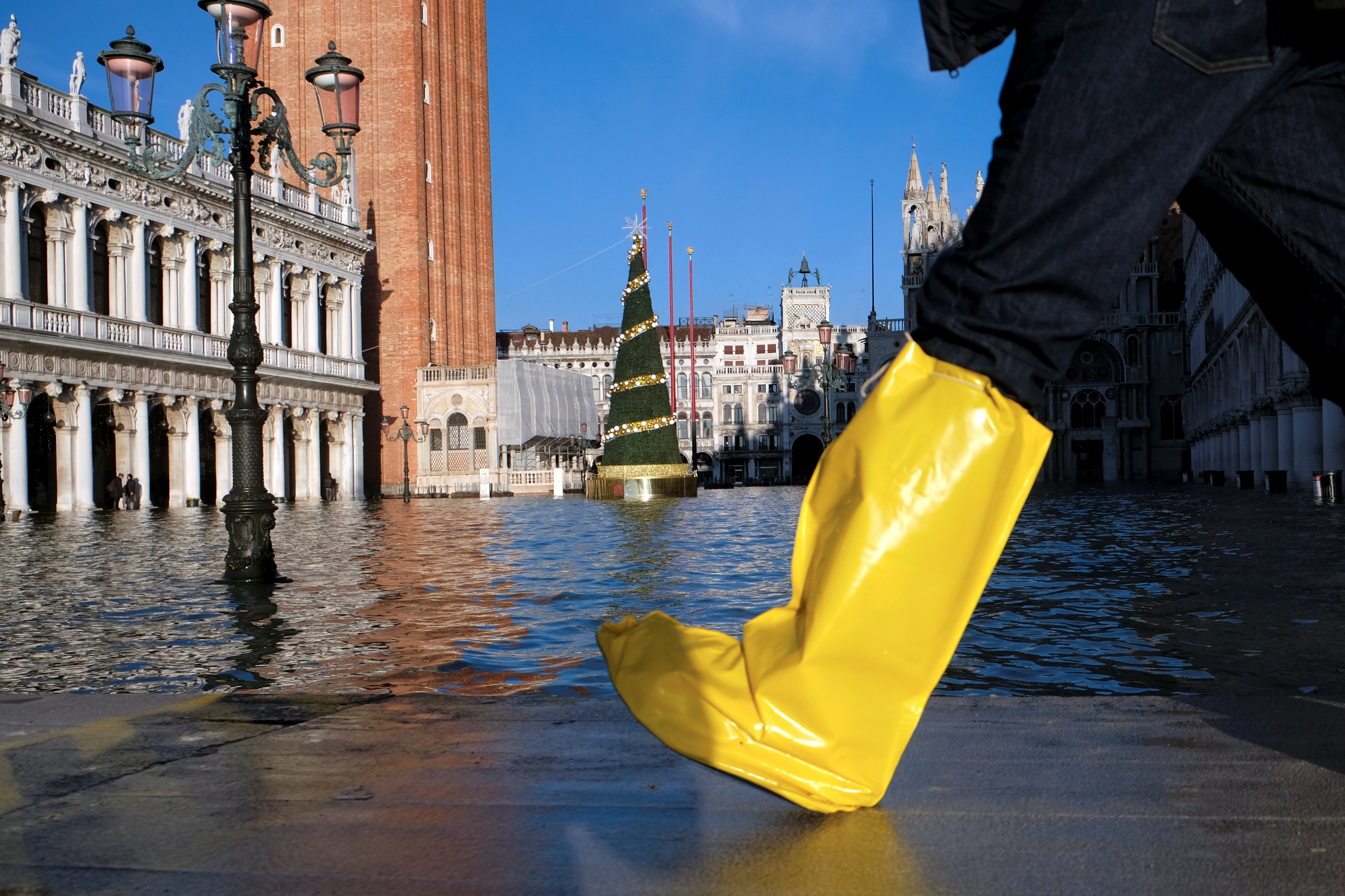 Una persona camina en la Plaza de San Marcos durante la marea alta en Venecia, Italia, el 24 de diciembre de 2019 (REUTERS/Manuel Silvestri)