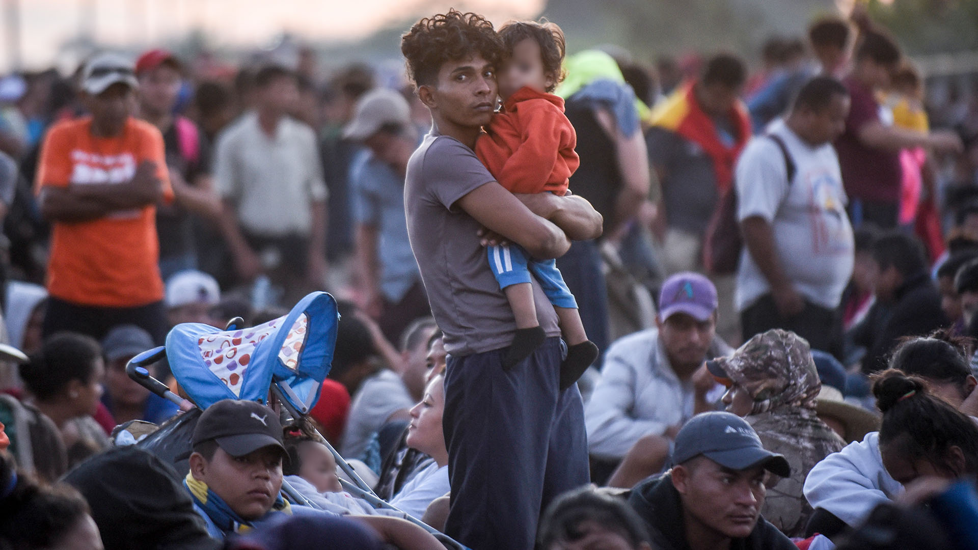 Integrantes de la caravana migrante esperan sobre el puente internacional que divide México y Honduras, con la esperanza de lograr cruzar la frontera entre estos dos países (Foto: Johan Ordoñez/AFP)