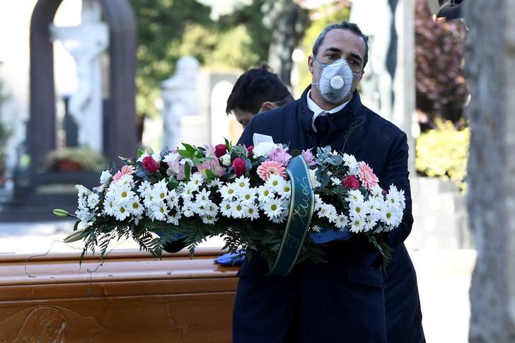 FOTO DE ARCHIVO. Trabajadores del cementerio y de una funeraria con mascarillas protectoras transportan un ataúd de una persona que murió por coronavirus (COVID-19), en Bérgamo, Italia. 16 de marzo de 2020. REUTERS/Flavio Lo Scalzo.