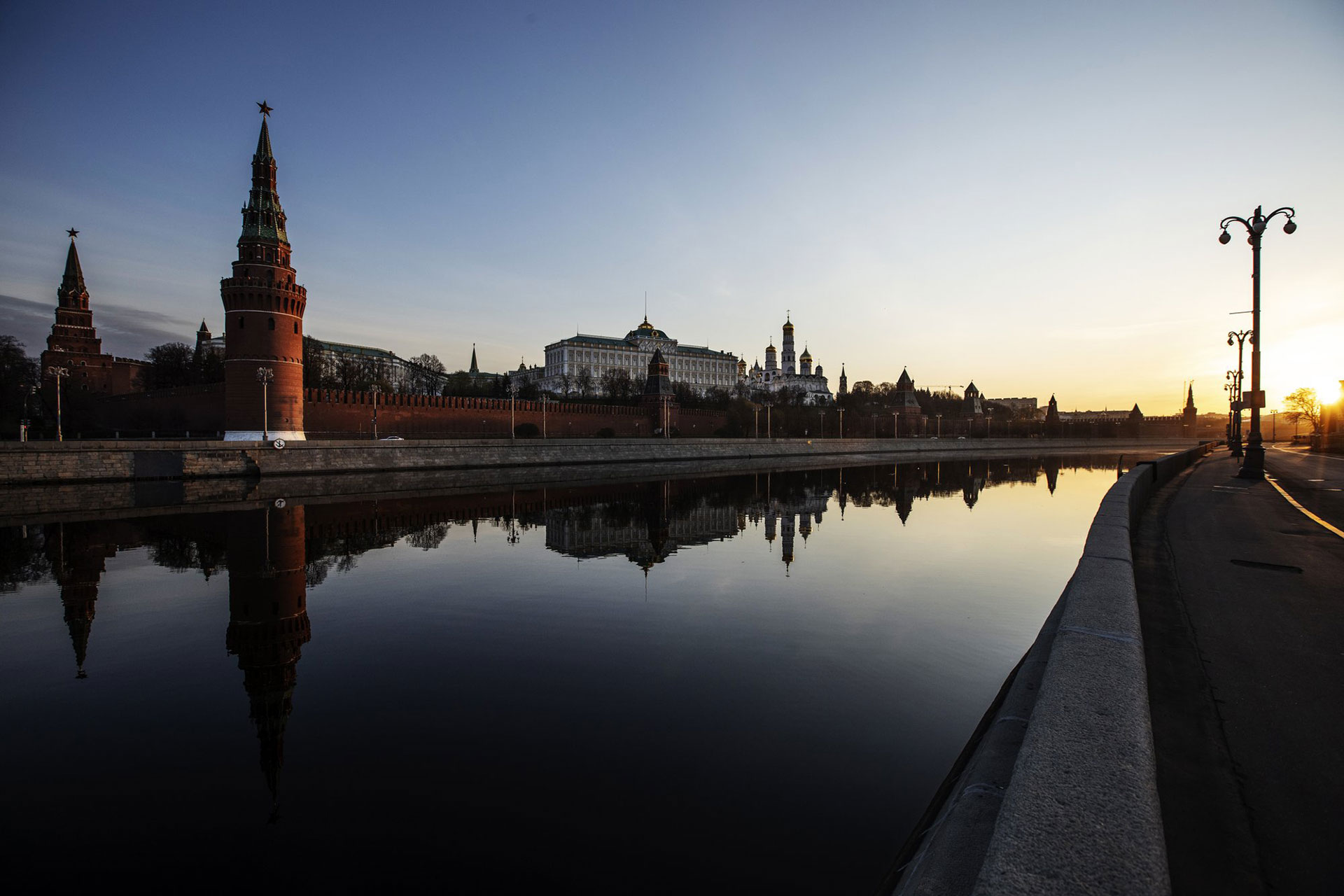 El Kremlin y sus torres se reflejan en el río Moscú a lo largo de un terraplén desierto cuando sale el sol sobre la capital de Rusia, el lunes 27 de abril de 2020. (Foto AP / Alexander Zemlianichenko)